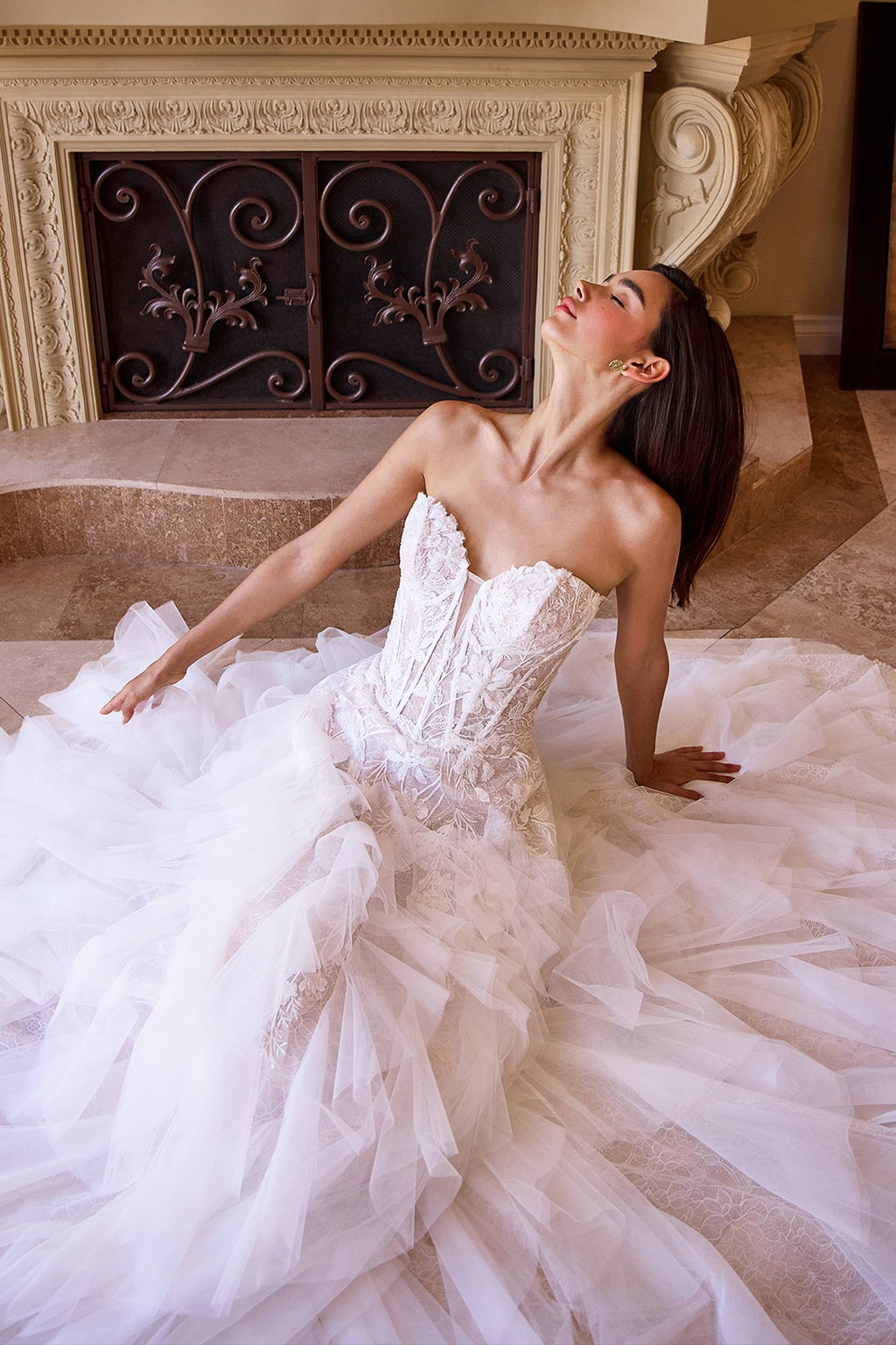 Strapless off-white wedding dress with lace bodice and voluminous cascading tulle skirt