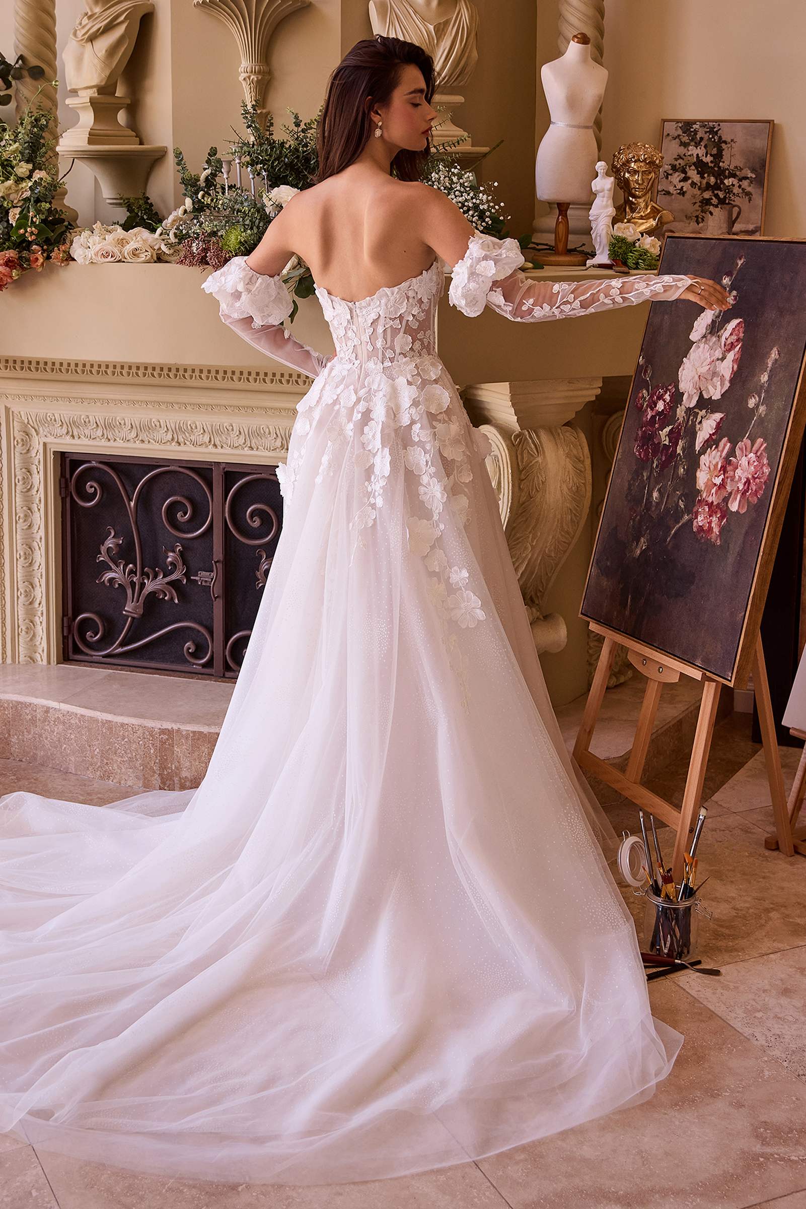 Off-white strapless wedding gown with floral applique corset, long flowing skirt, sheer sleeves