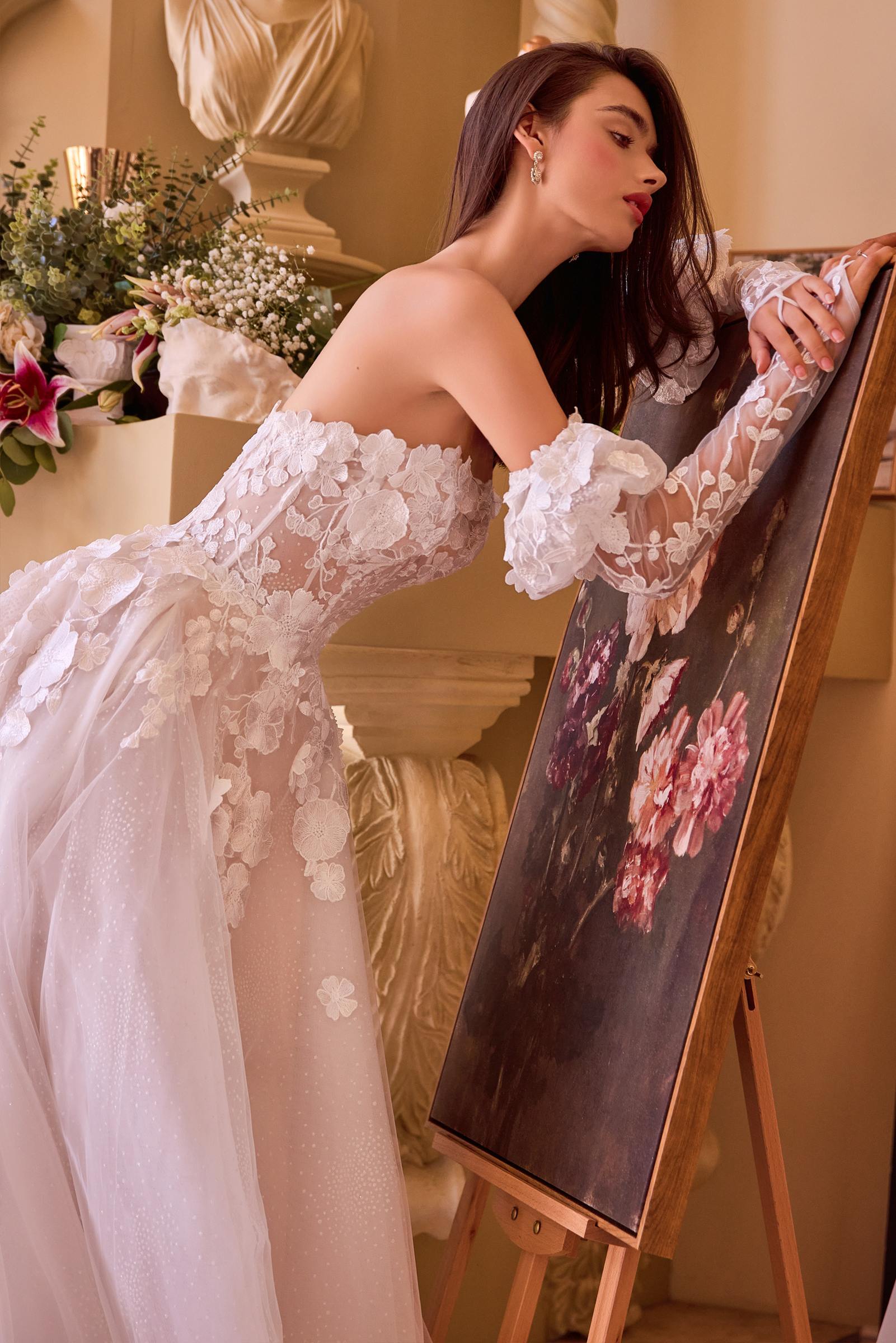 Off-white strapless wedding gown with floral lace back panels and sheer sleeves