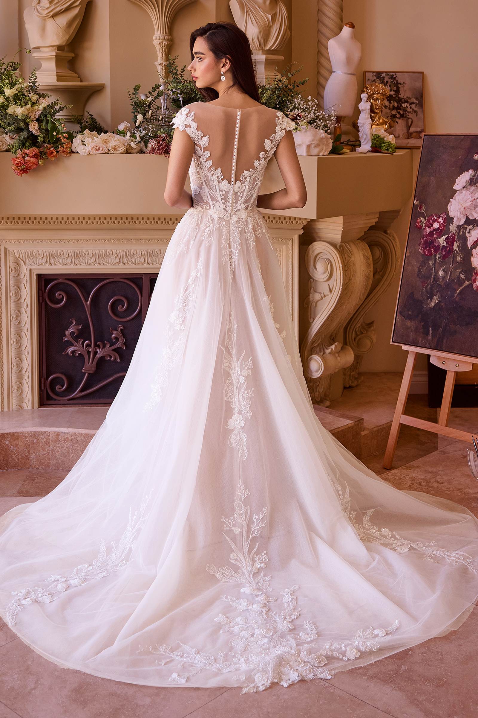 Off-white long bridal gown with open-back lace detail and sheer cap sleeves