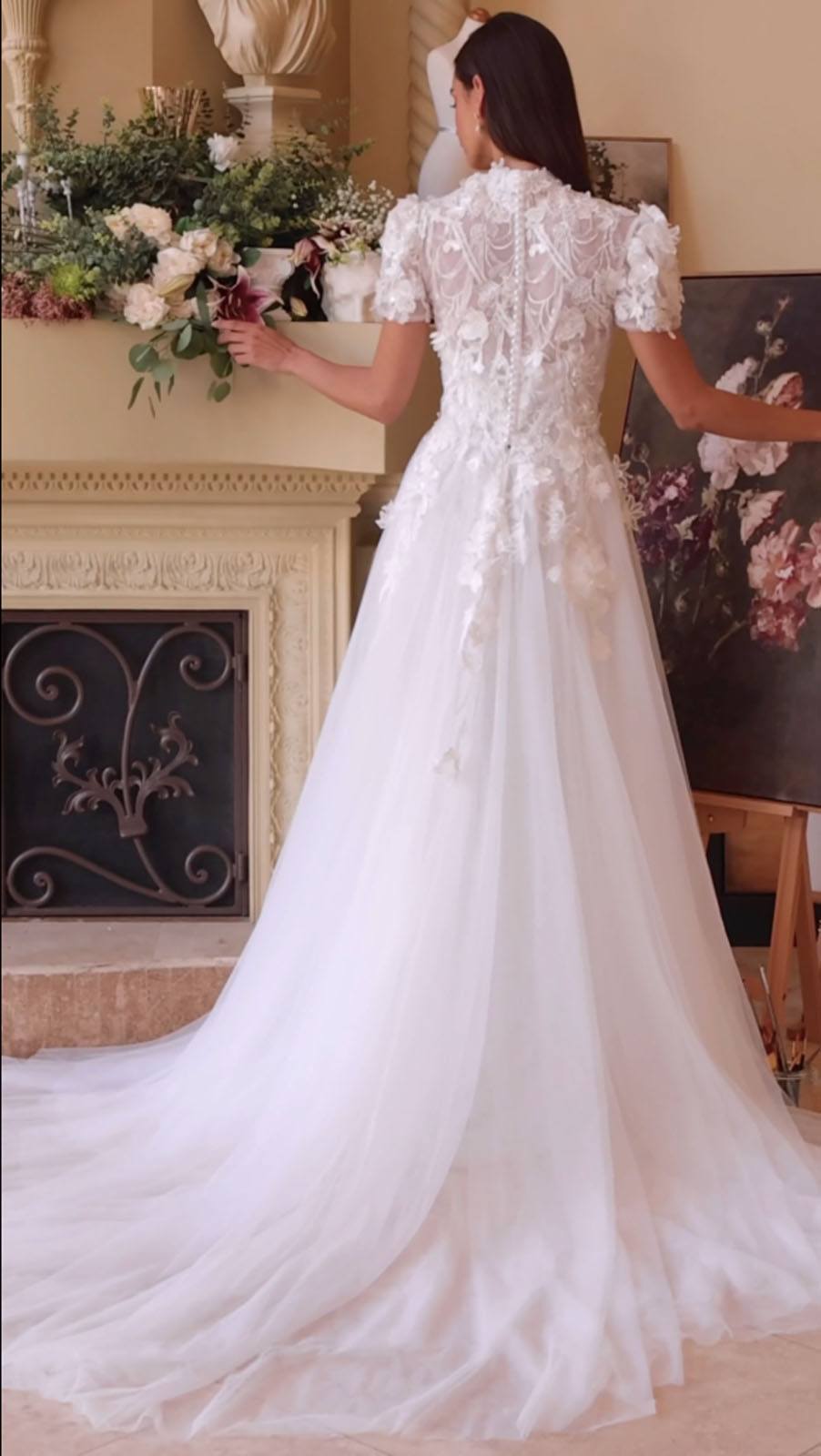 Off-white lace wedding dress back view with short cap sleeves and flowing skirt