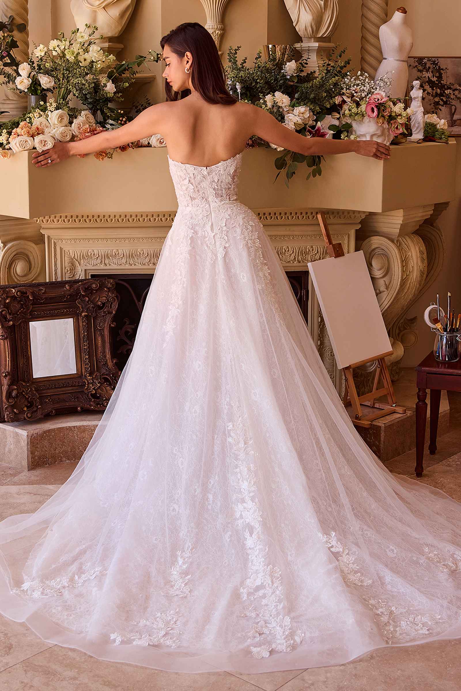 Off-white strapless ball gown with lace bodice, open back, and full tulle skirt