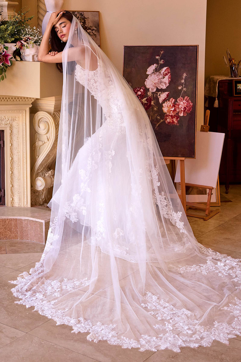 Off-white lace wedding gown with long veil and sheer draped tulle skirt