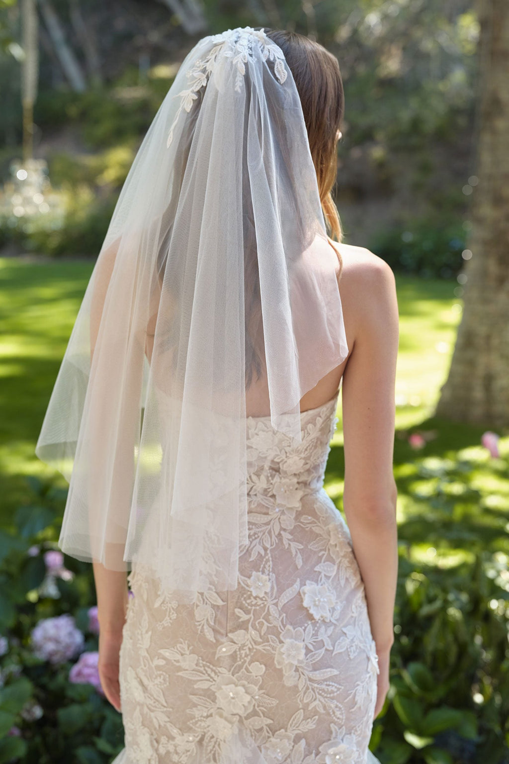 Lace wedding gown with layered tulle veil at the back