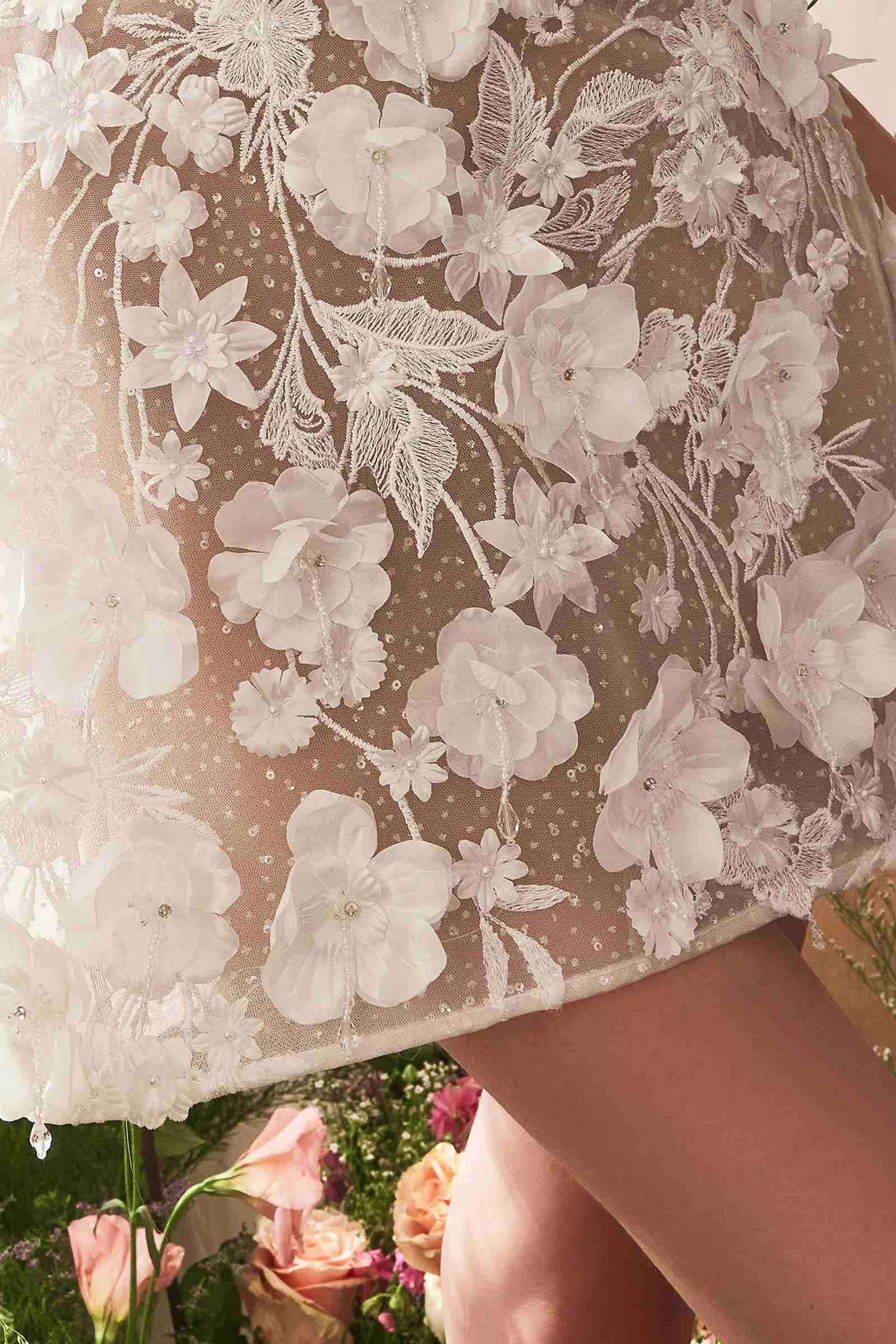 Floral lace appliqué overlay on sheer bodice, off-white