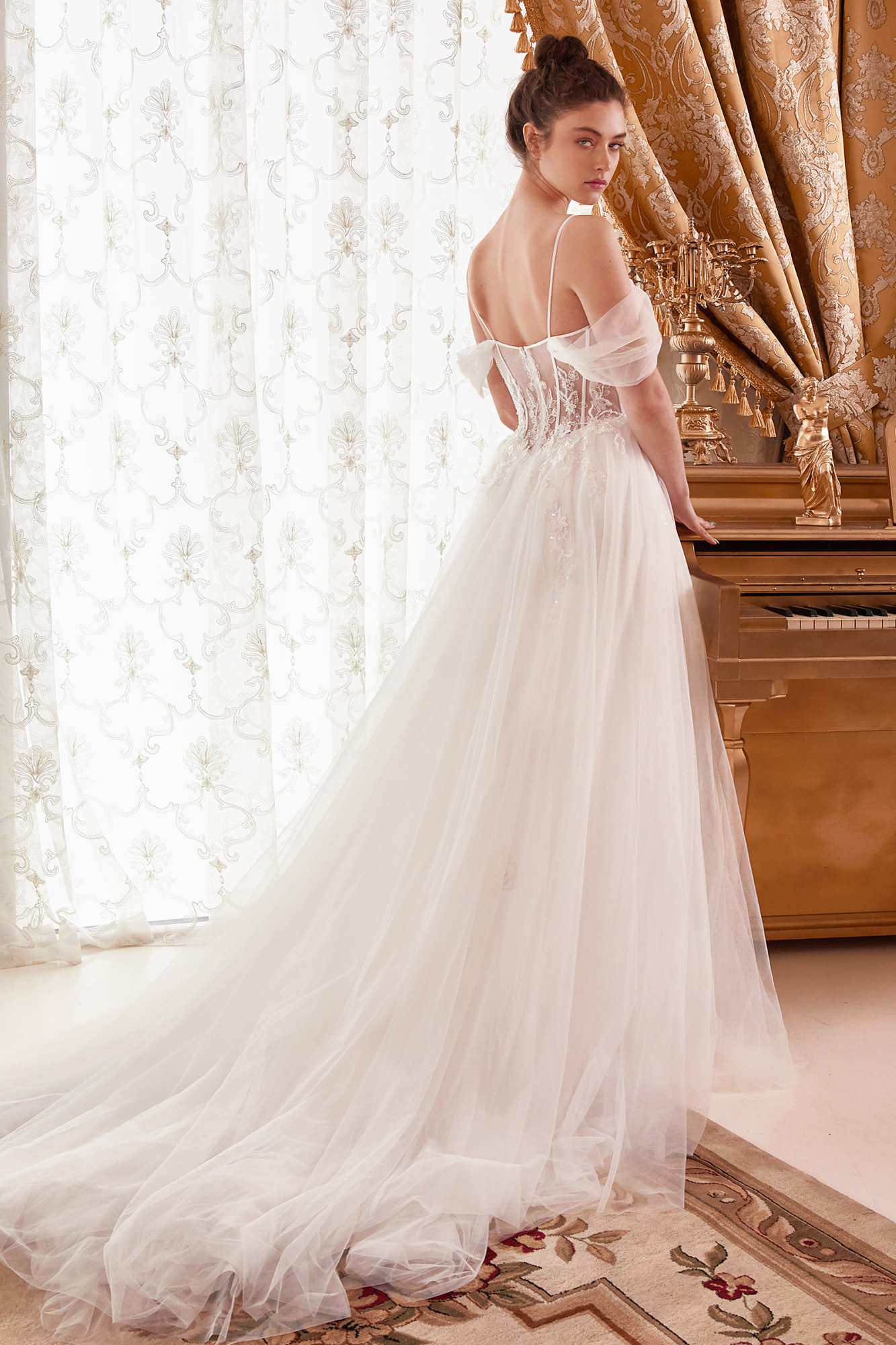 Off-white layered tulle A-line bridal gown with corset bodice and sheer off-shoulder sleeves
