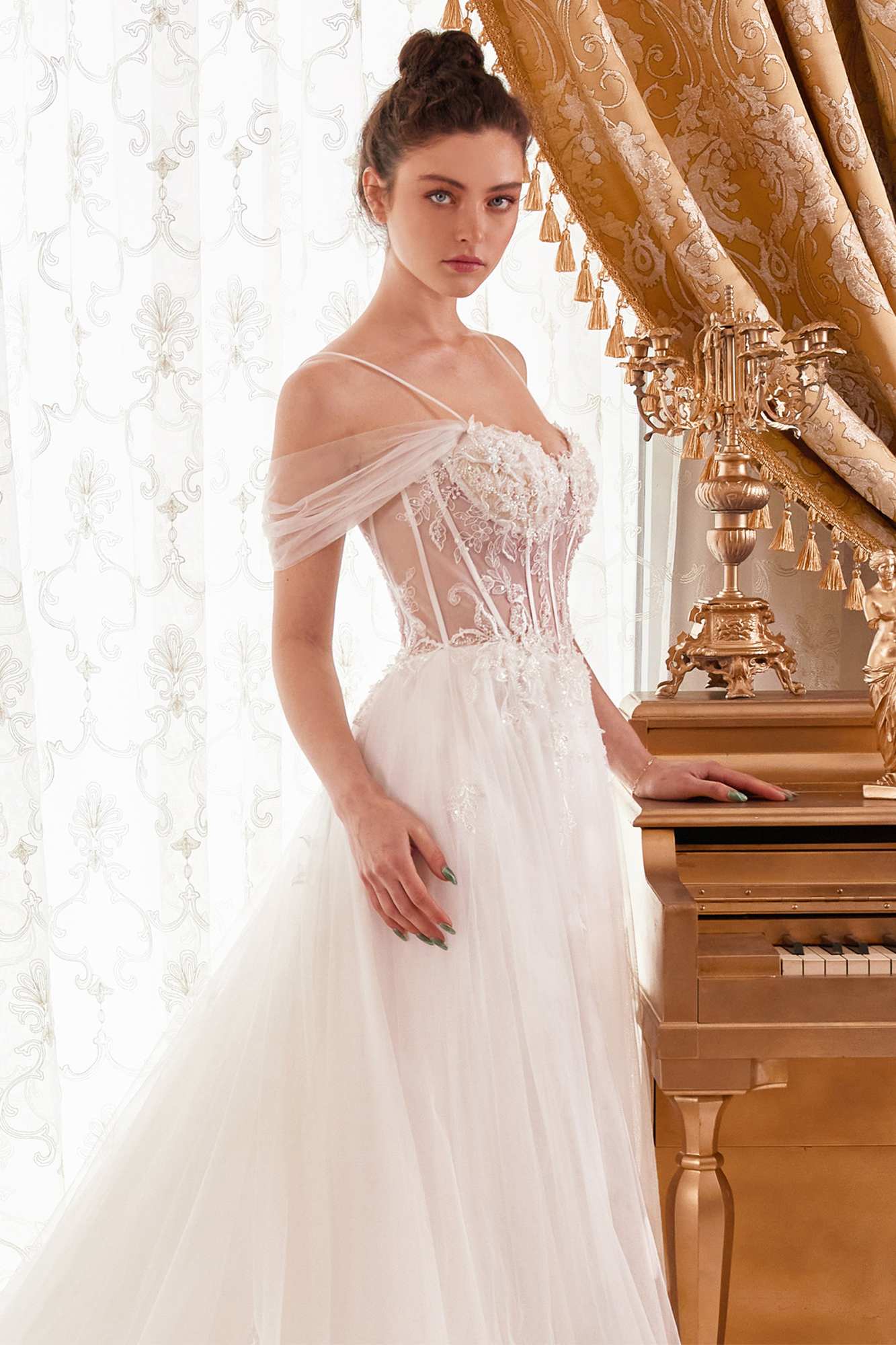 Off-white layered tulle A-line bridal gown with corset bodice, lace details, and thin straps