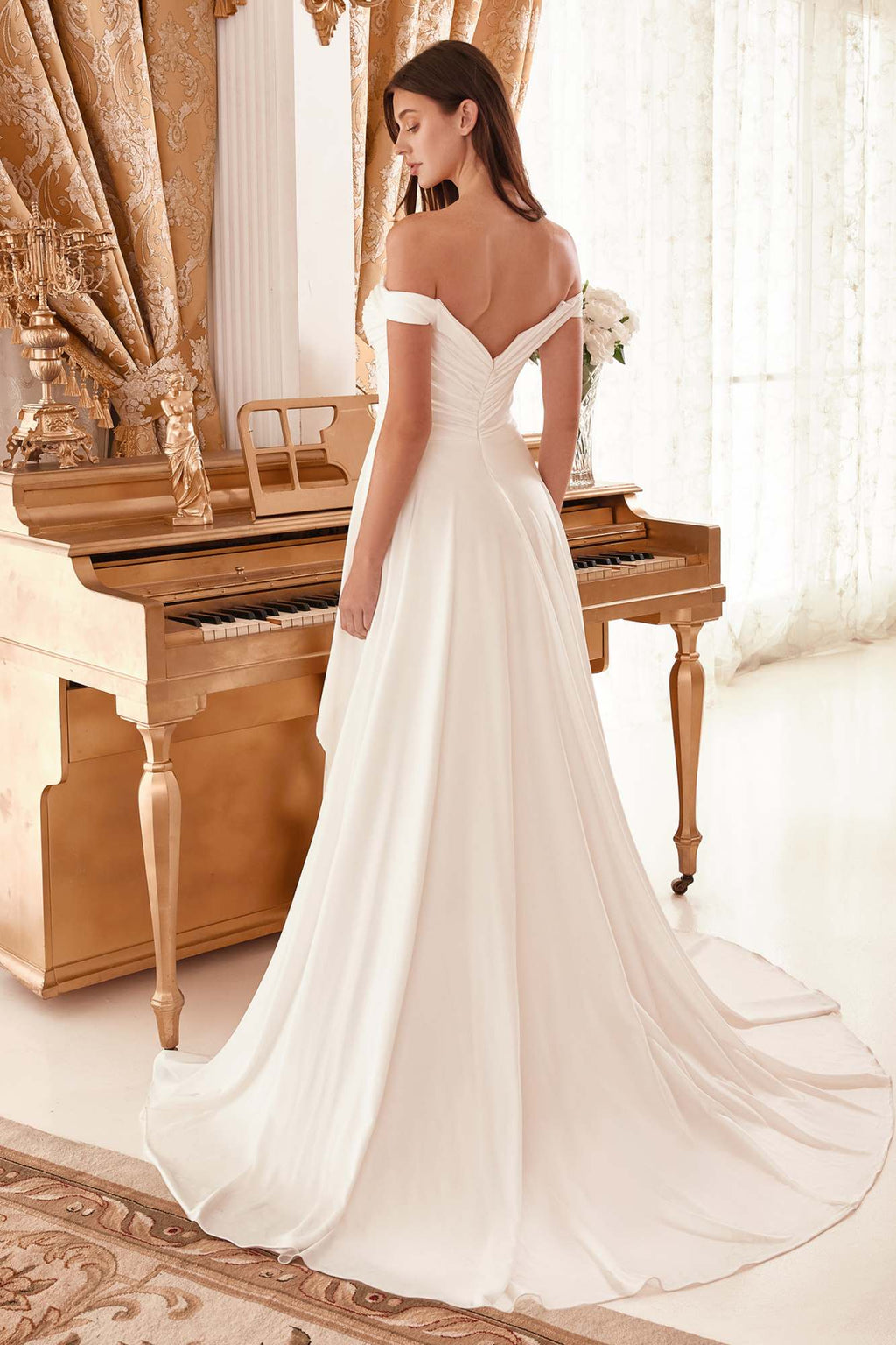 Off-white off-shoulder bridal gown with draped bodice, back view, and long flowing train