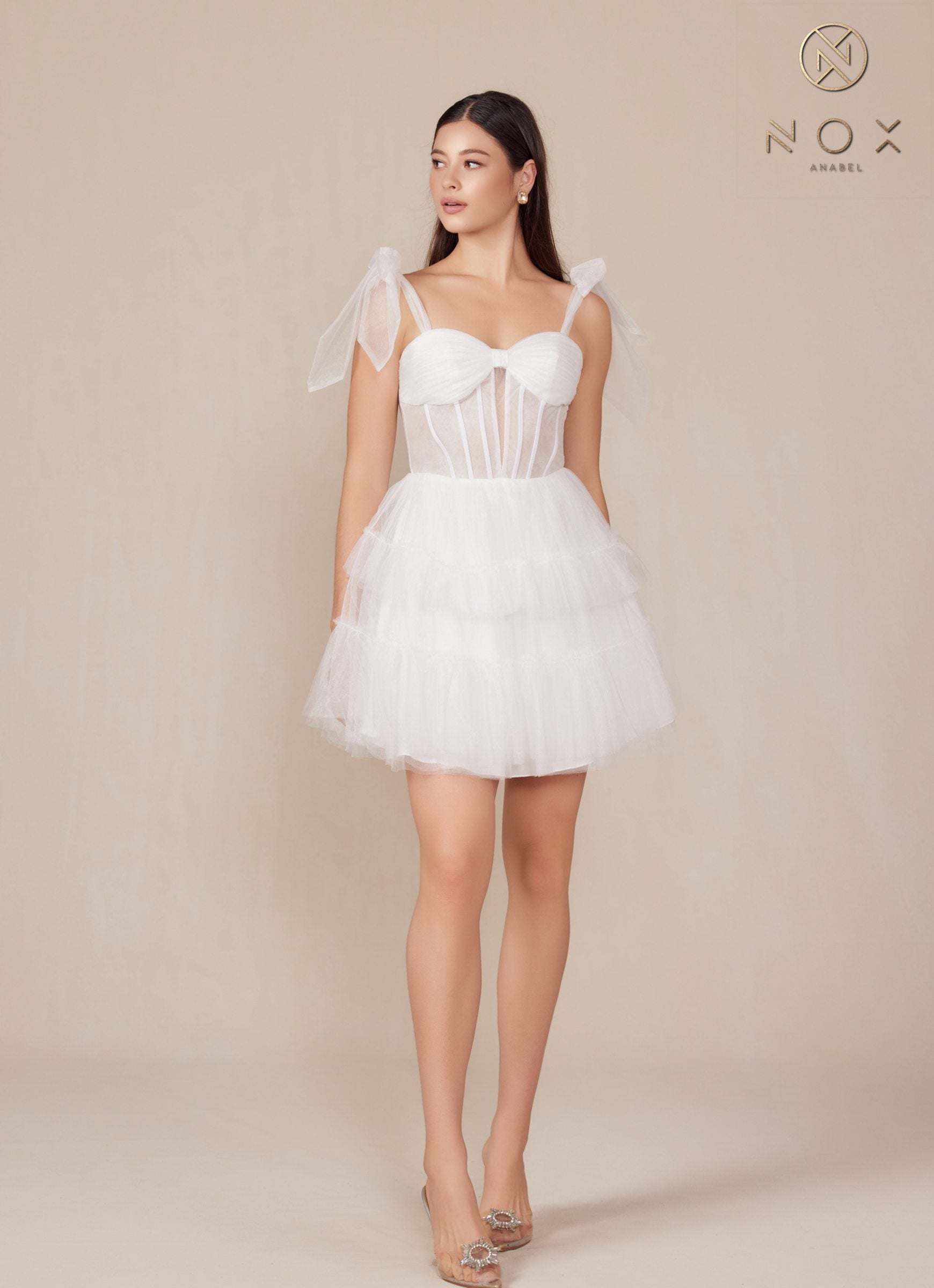 White A-line tulle dress with sweetheart neckline, bow shoulder ties, tiered ruffle skirt