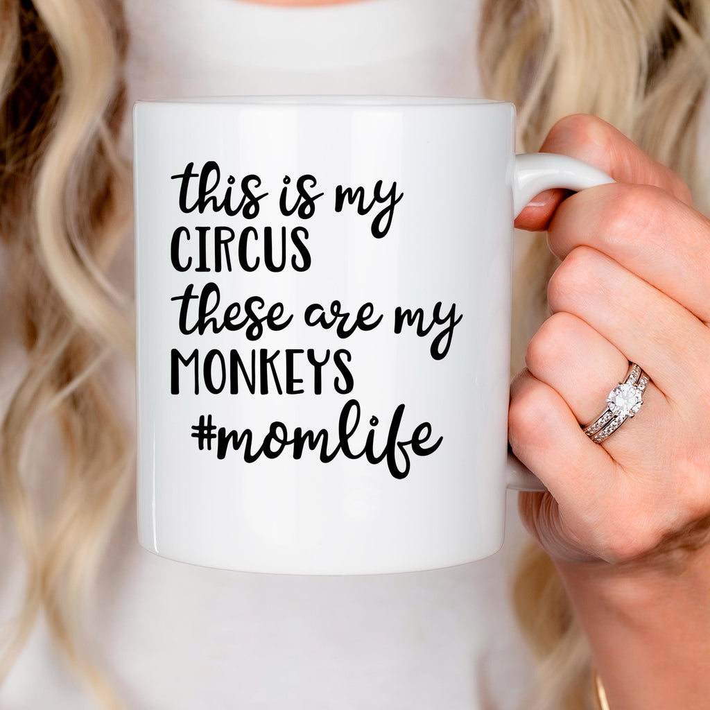 White ceramic coffee mug held in hand, showing "Circus" momlife message
