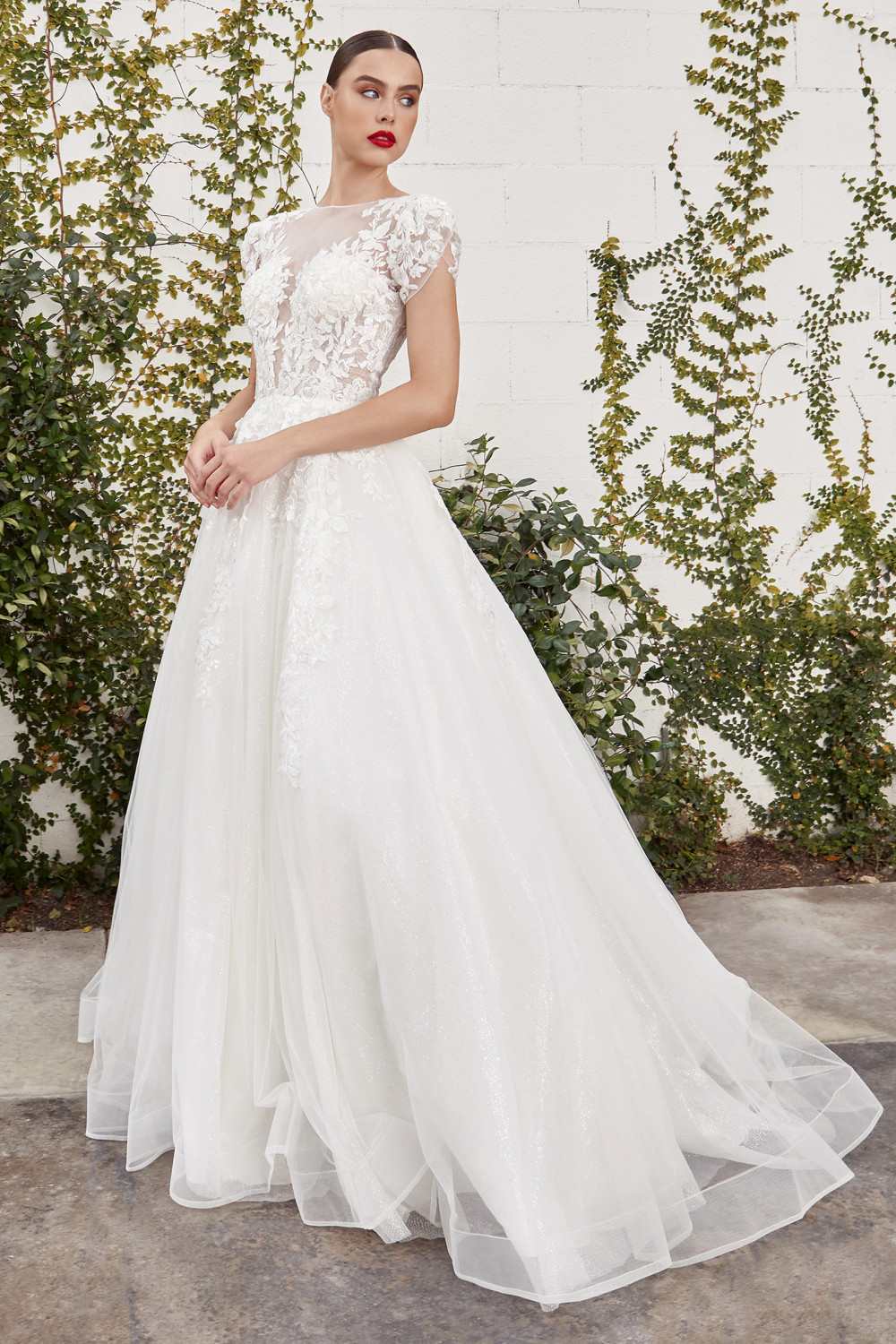 Off-white bridal gown with lace-embellished neckline, fitted bodice and voluminous tulle skirt