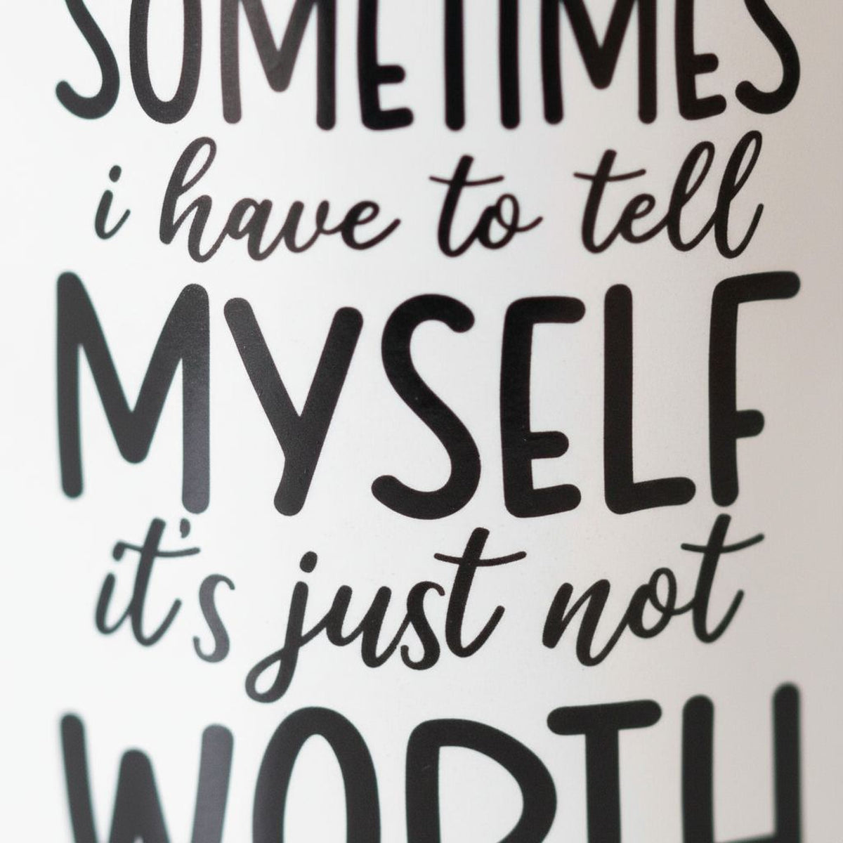 Close-up of white ceramic coffee mug text: “SOMETIMES…MYSELF…WORTH”