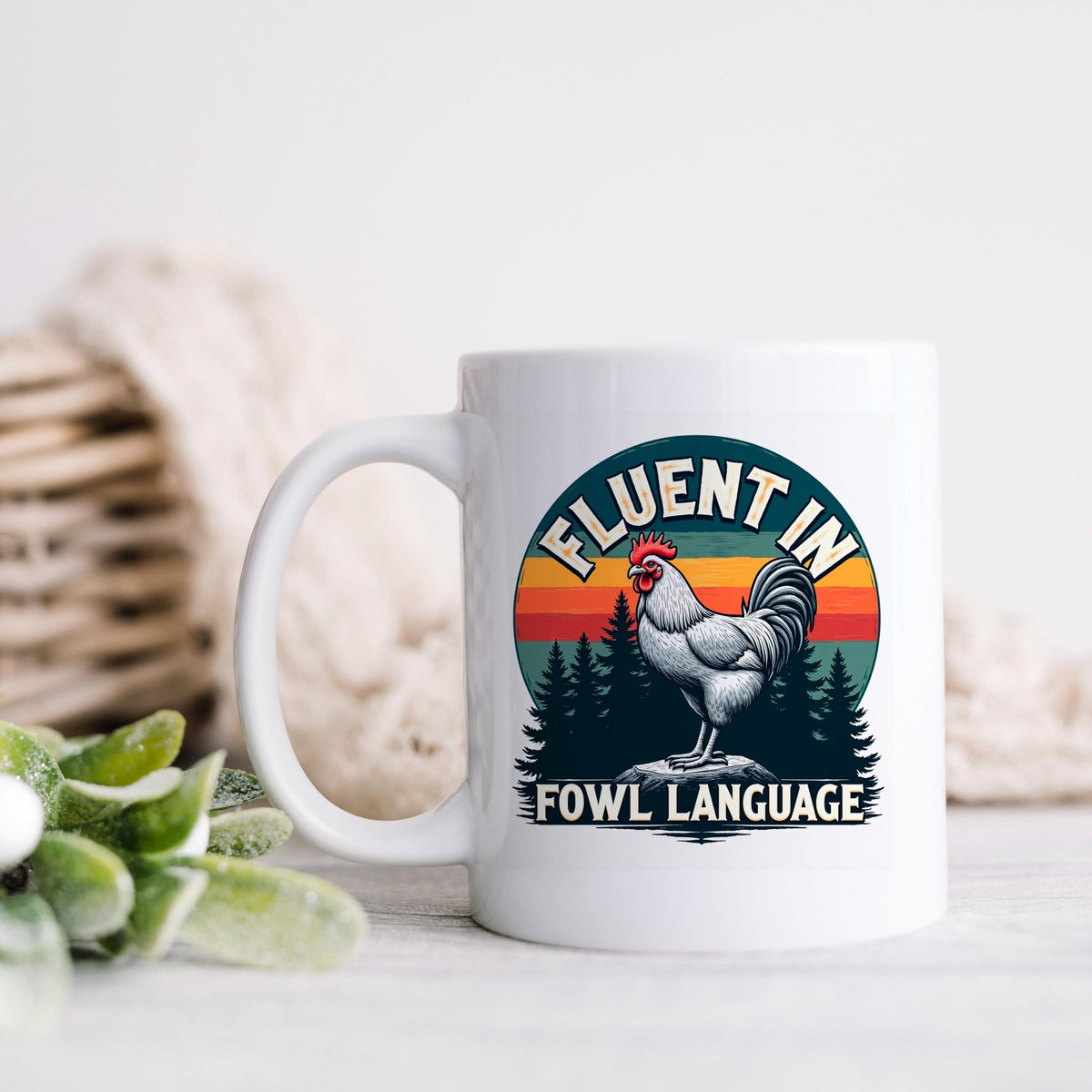 White ceramic coffee mug with rooster logo and “FLUENT IN FOWL LANGUAGE” text