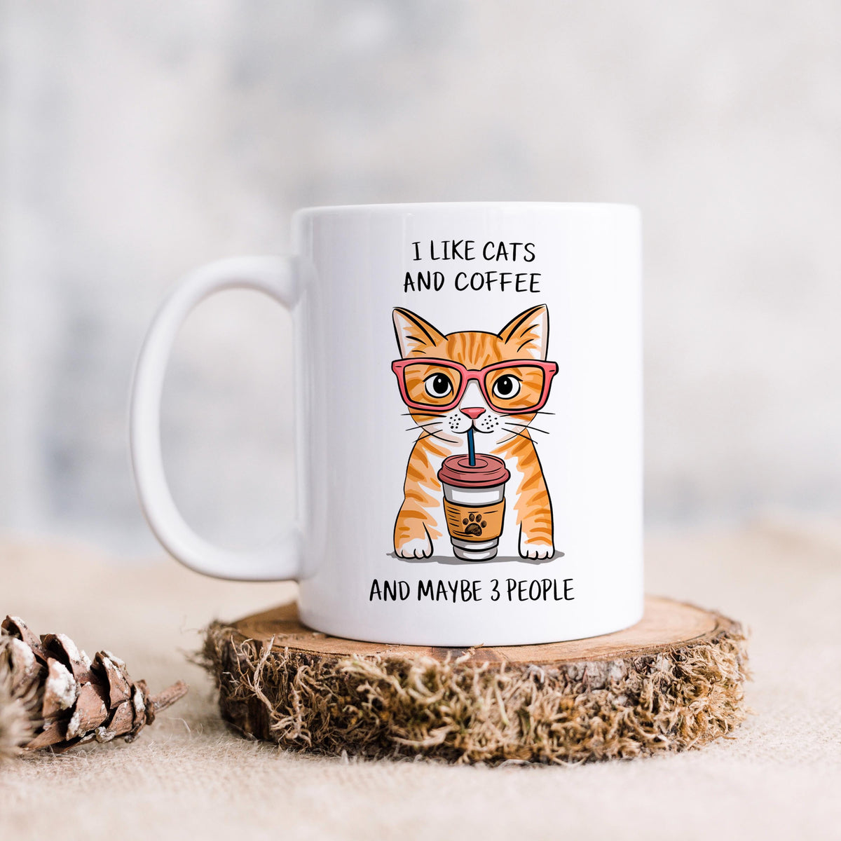 White ceramic mug with orange tabby cat holding coffee cup, on round coaster