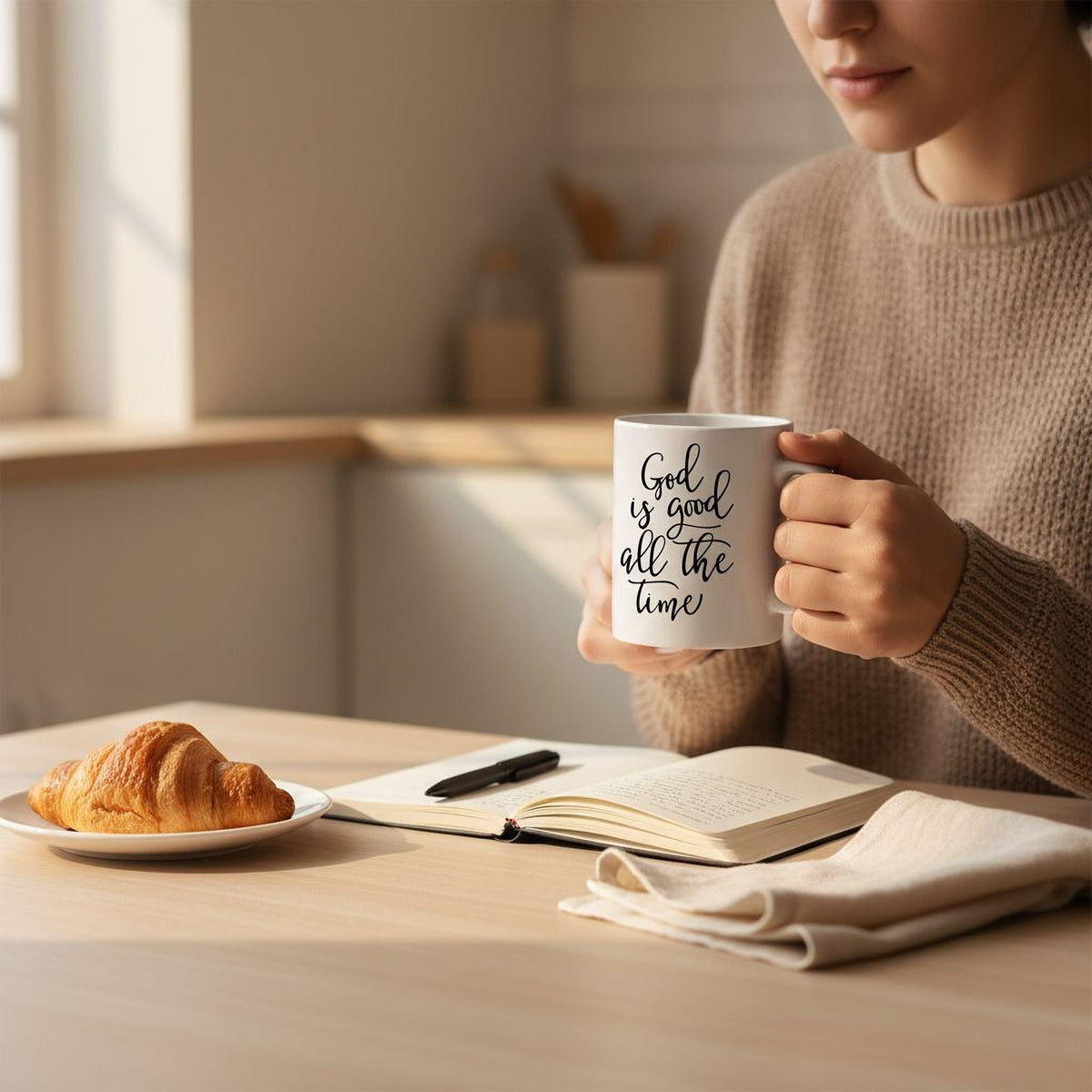 White ceramic coffee mug with 'God is good all the time' text, held in hand