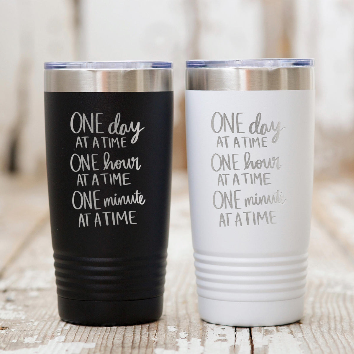 Black and white stainless steel tumblers with motivational “One day at a time” print