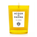 Yellow glass jar candle with ACQUA DI PARMA label and visible wick flame