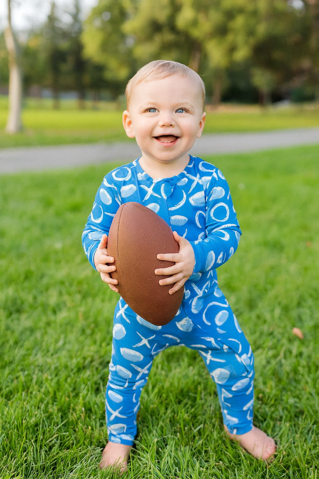 Allen Work convertible romper in blue with sports ball print, long sleeves, footed legs