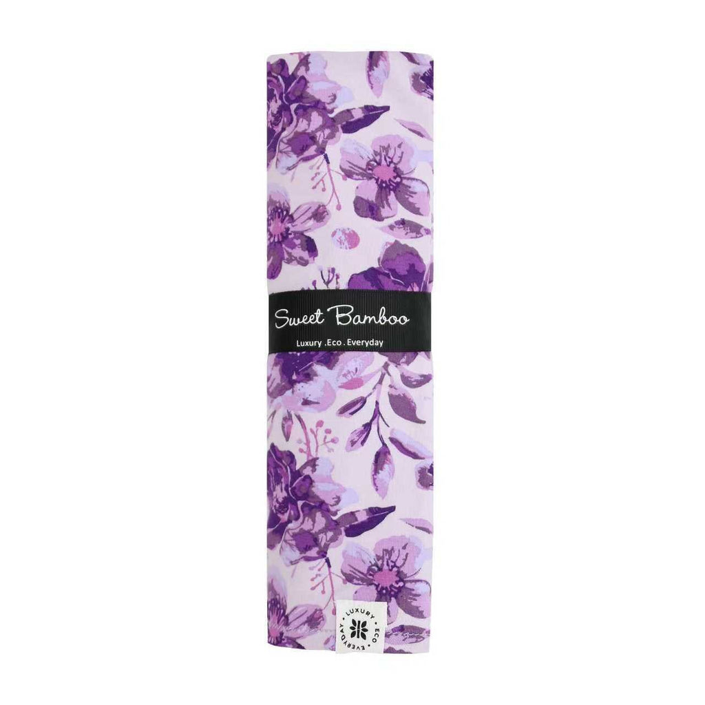 Purple floral swaddle wrap folded, Sweet Bamboo logo and patterned design