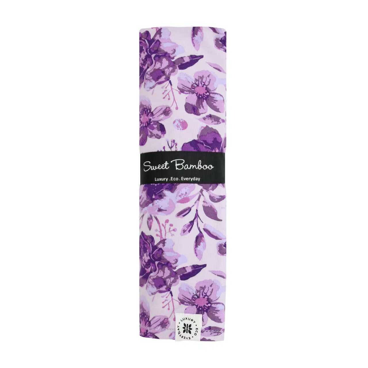 Purple floral swaddle wrap folded, Sweet Bamboo logo and patterned design