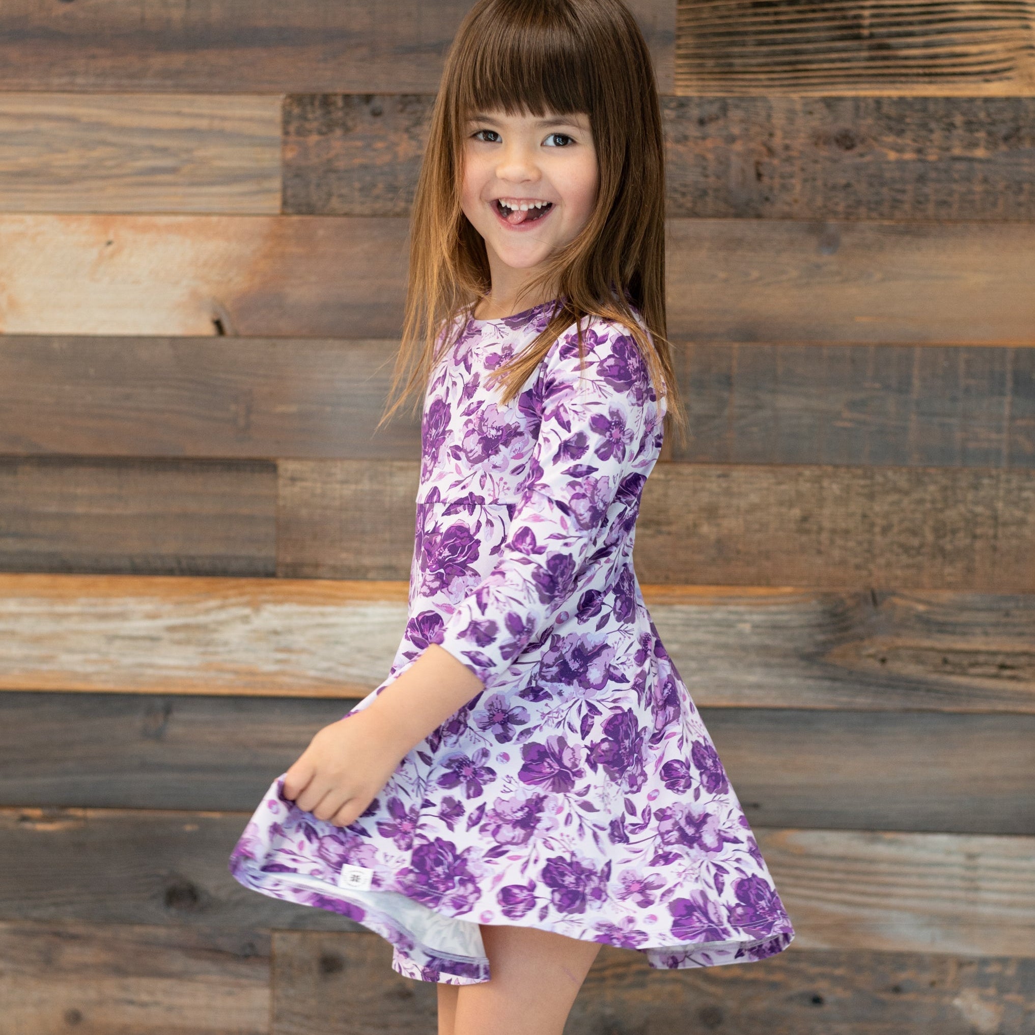 Girls purple floral long-sleeve dress with gathered skirt, side view