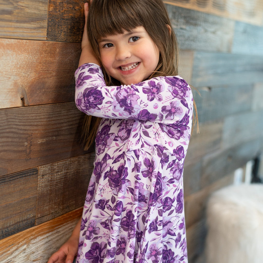 Girls purple floral long-sleeve dress with gathered skirt, hugging pose, close-up