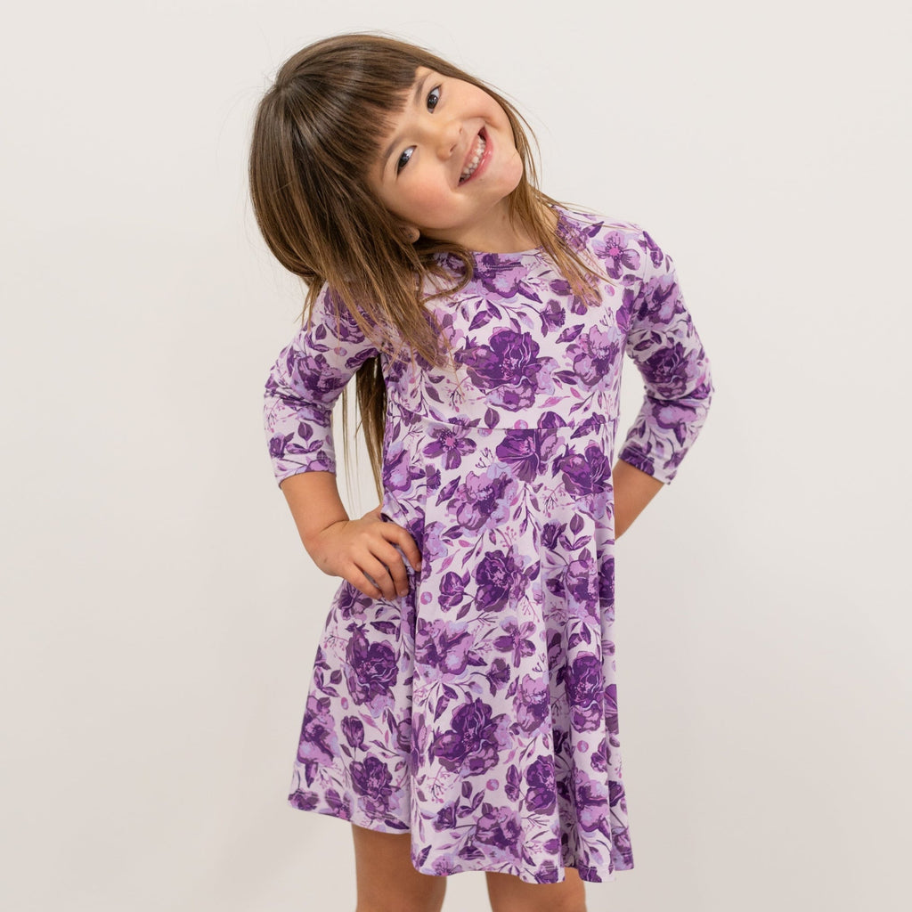 Girls purple floral long-sleeve dress with gathered skirt, standing full-body view