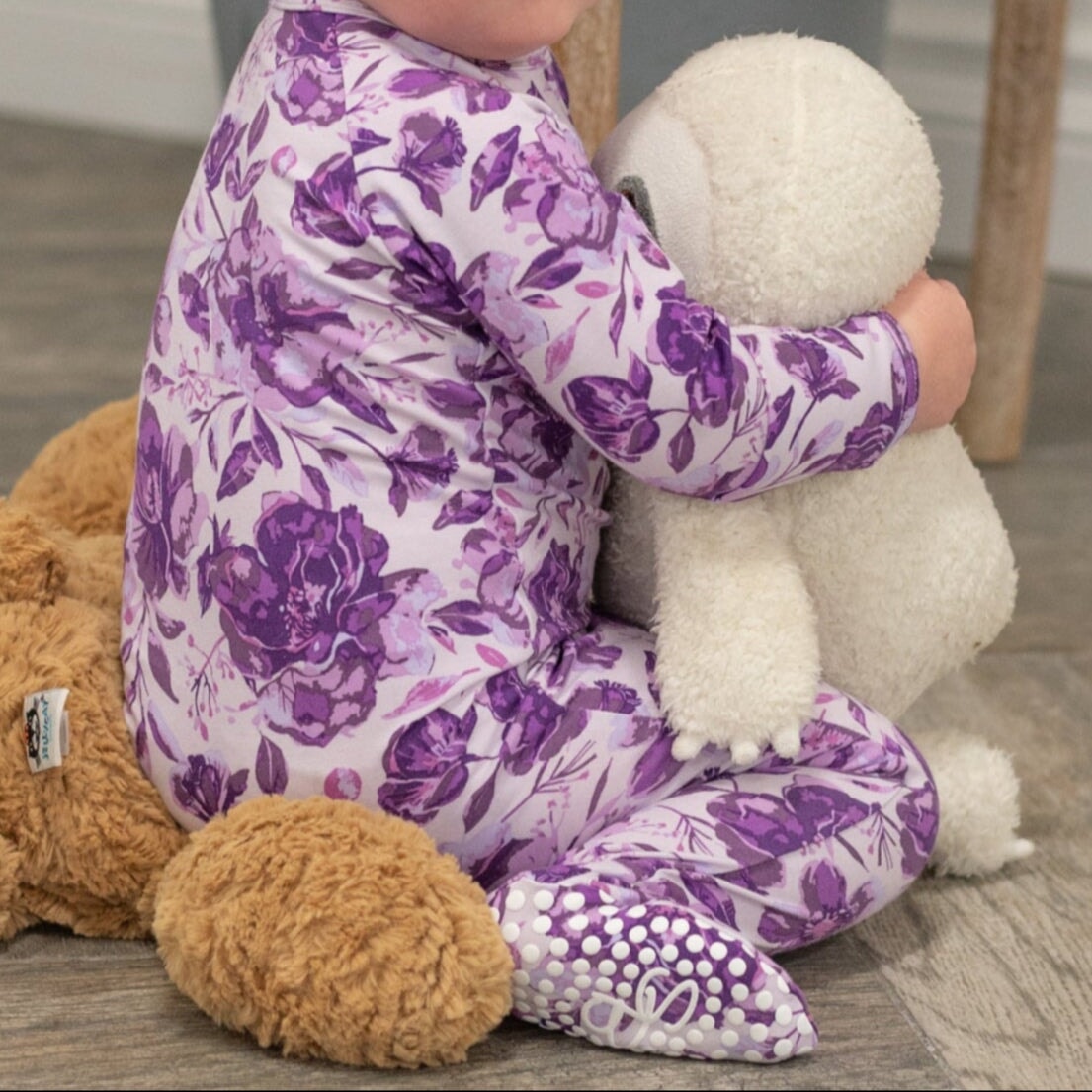 Purple floral zipper footie pajama with footed legs and long sleeves, zip front.