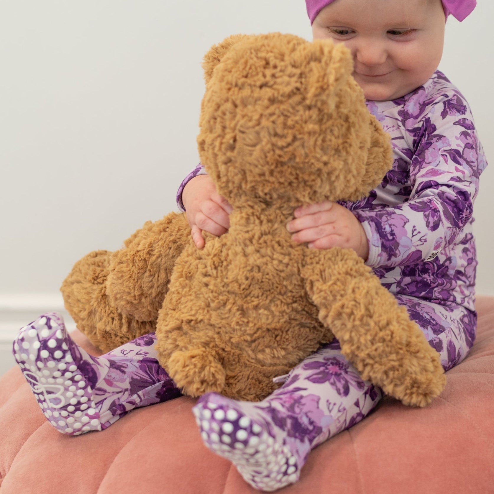 Purple floral zipper footie pajama with long sleeves and footed legs, zip front visible.