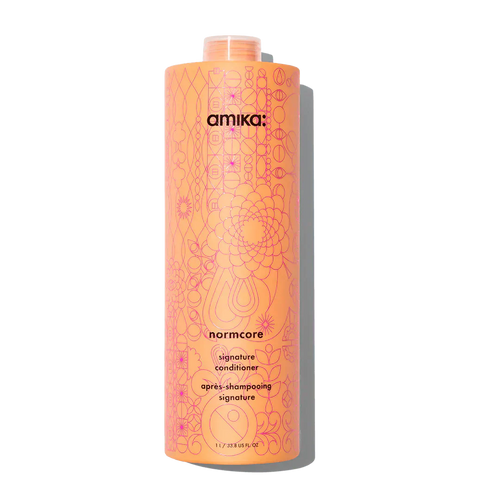 Hair conditioner bottle with orange-pink patterned label and purple top