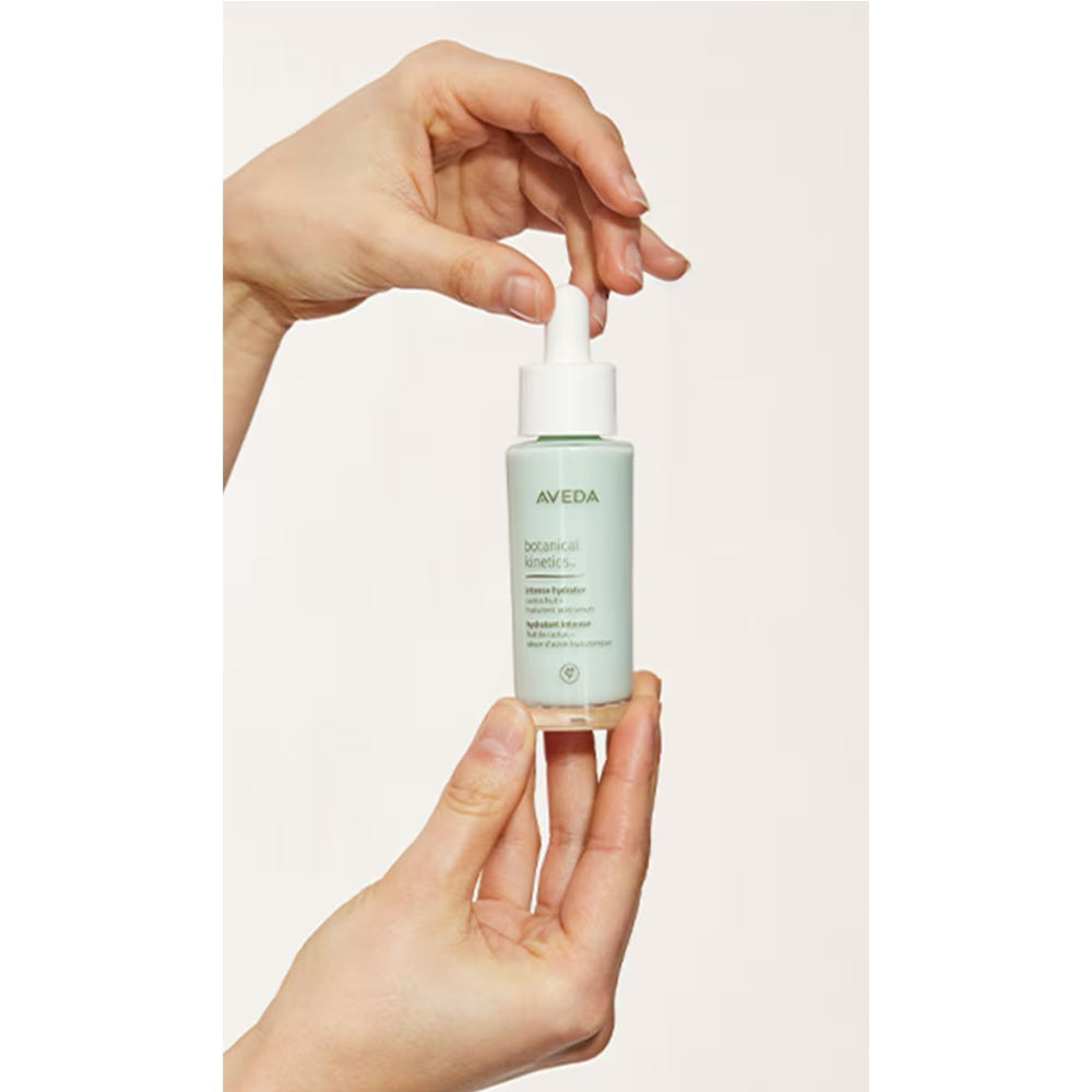 Hands using Aveda Botanical Kinetics Intense Hydrator with white pump