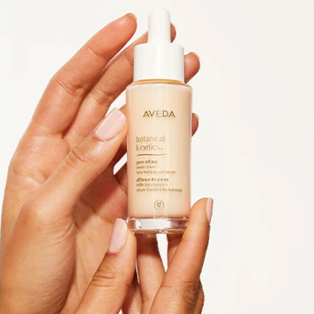 Aveda Botanical Kinetics pore refiner serum bottle held in hands, 30 mL