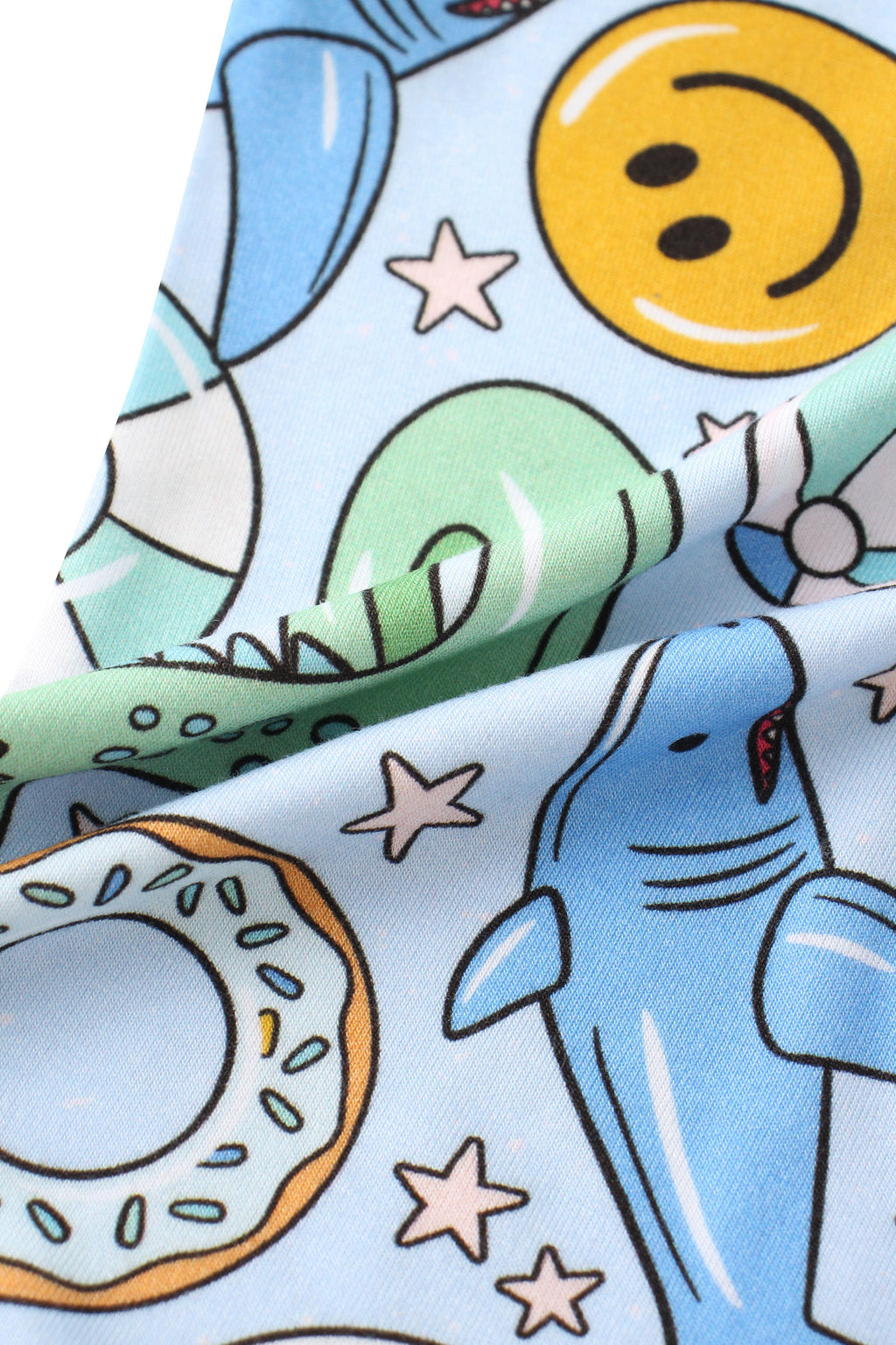 Baby romper fabric close-up with rockets, lifebuoys, stars, and smiling faces print