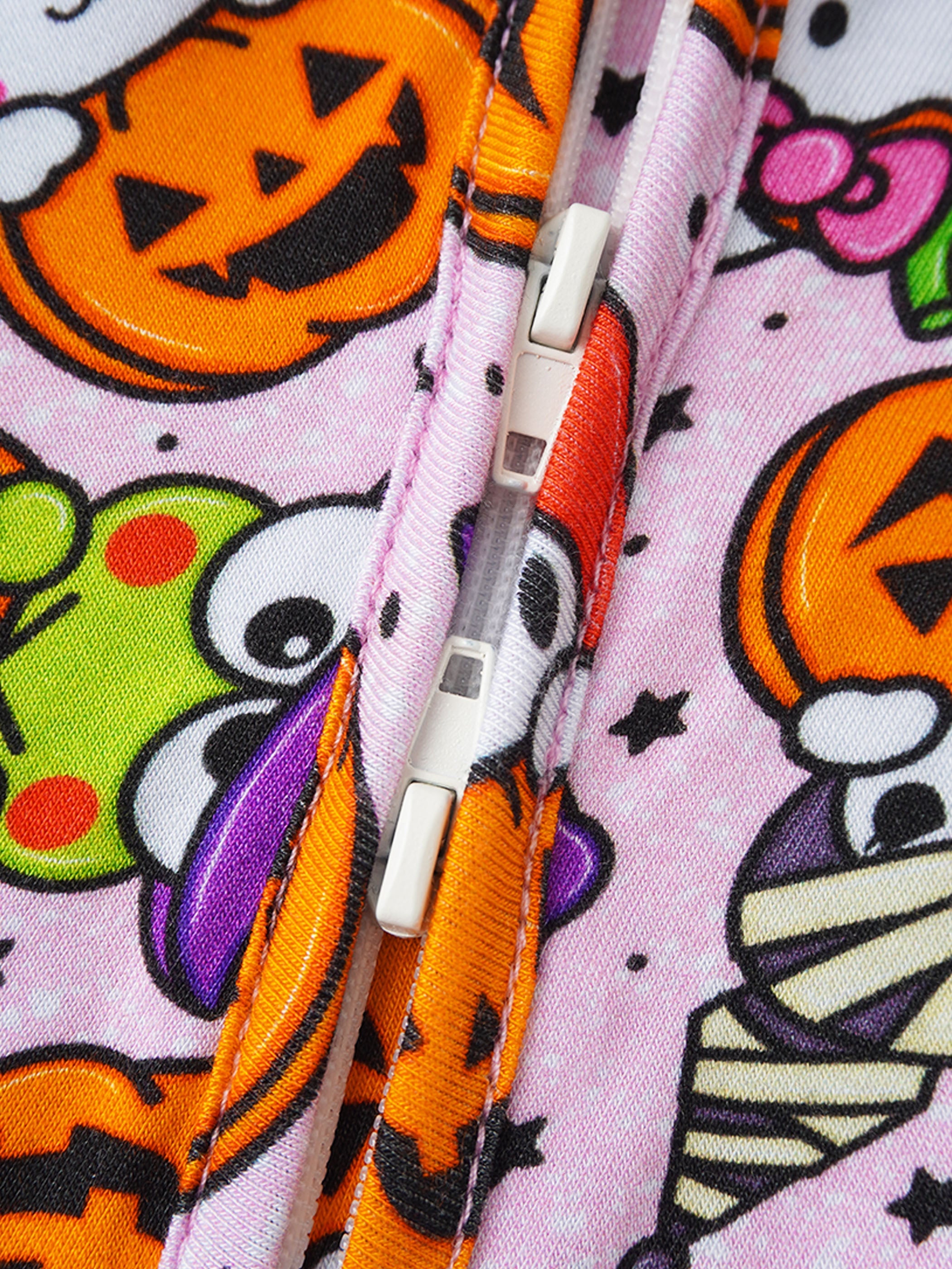 Baby romper zipper close-up on light lavender Halloween pumpkin print fabric