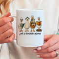 White ceramic coffee mug with four bookish goose characters and the phrase "just a bookish goose"