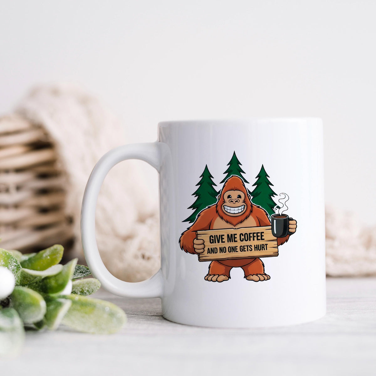 White ceramic coffee mug with Bigfoot graphic holding sign and steaming cup.