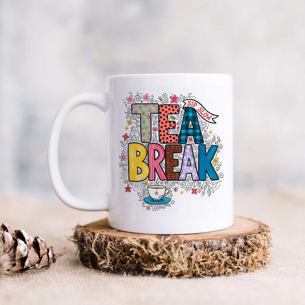 White ceramic tea mug with 'TEA BREAK' colorful floral design and handle