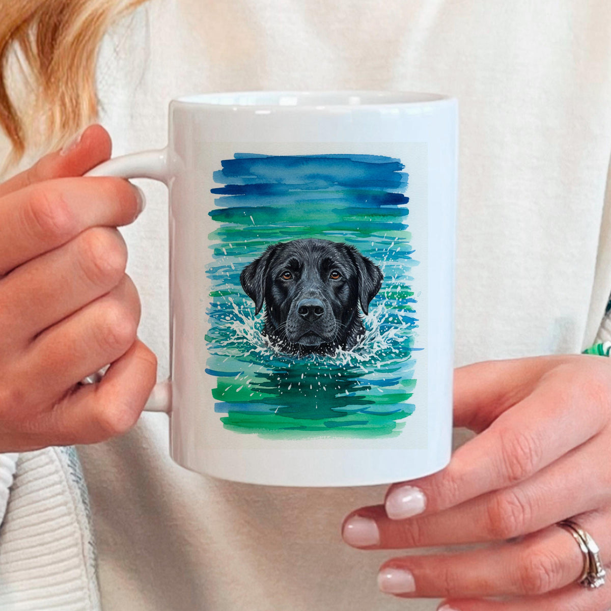 White ceramic coffee mug held in hands, watercolor black lab portrait on splash