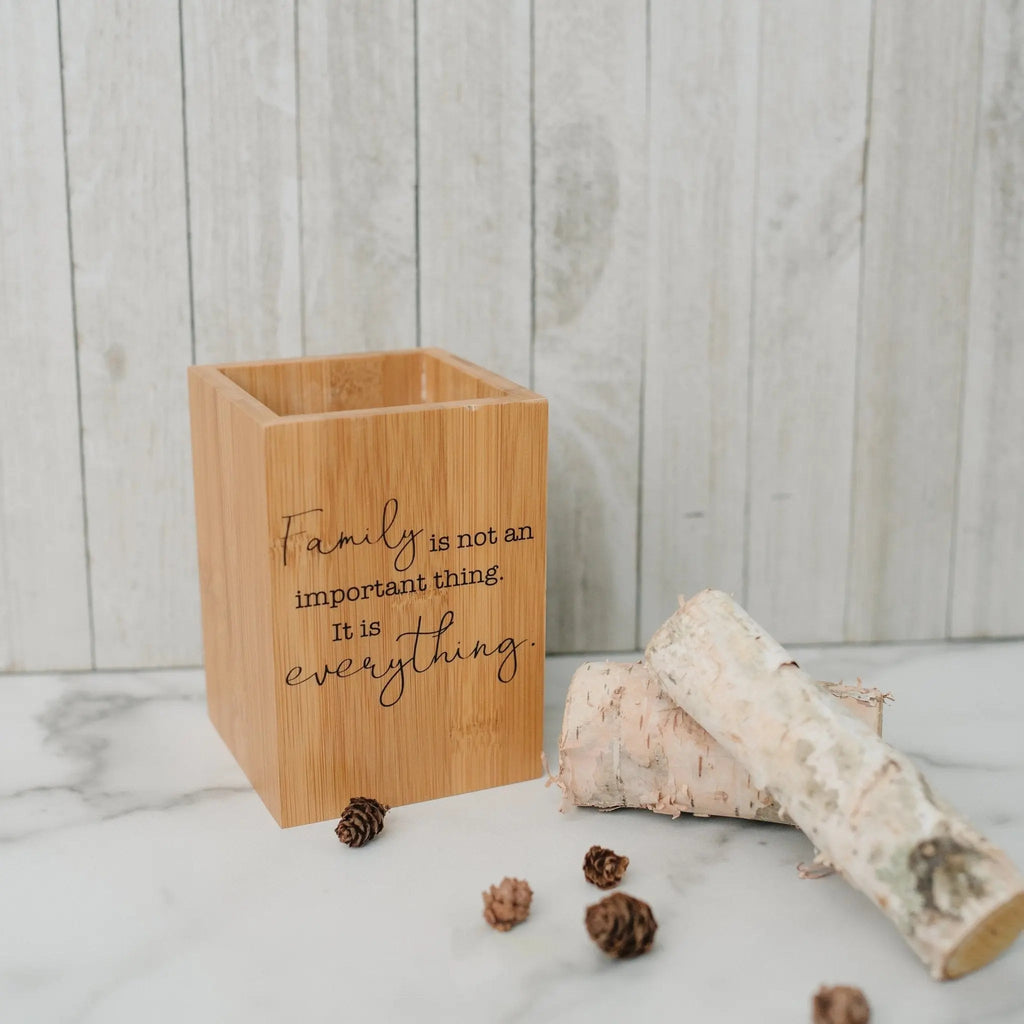 Bamboo utensil holder with quote text and wooden kitchen utensils inserted