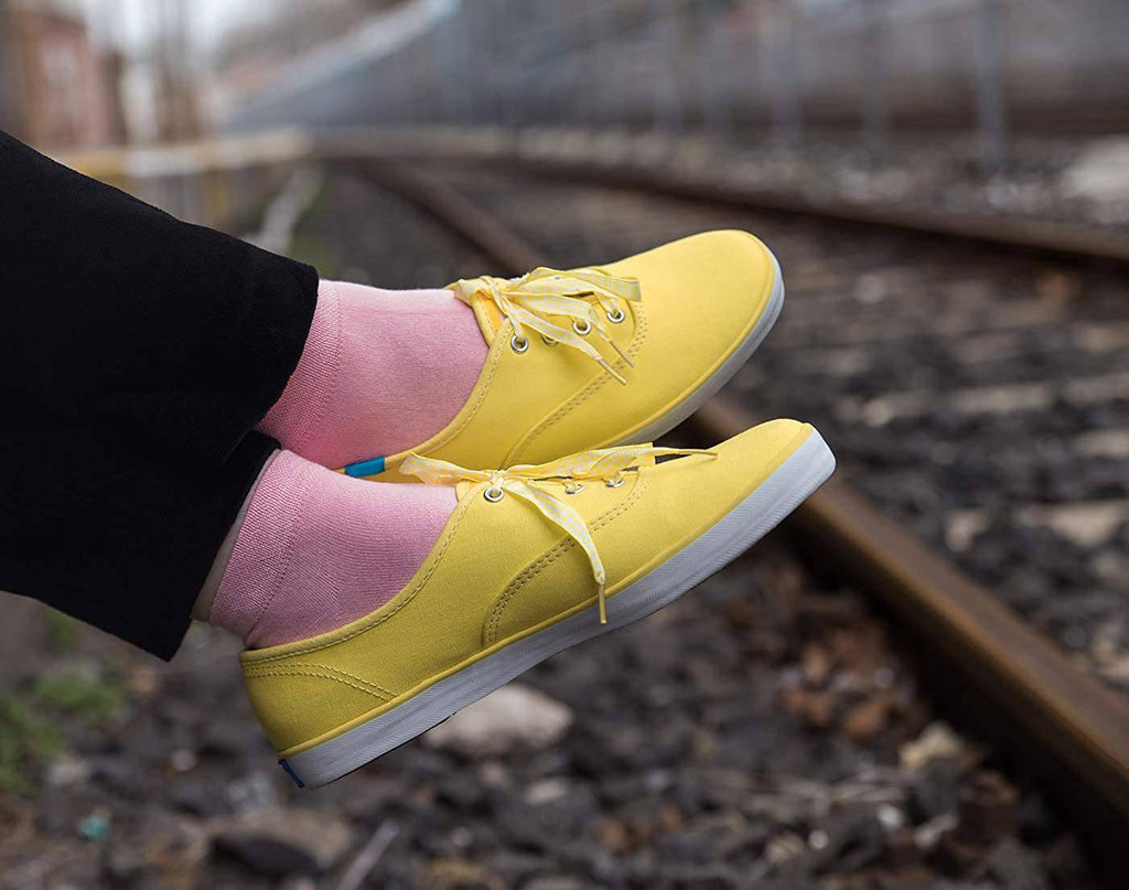 Yellow and pink low-cut ankle socks with laced sneakers