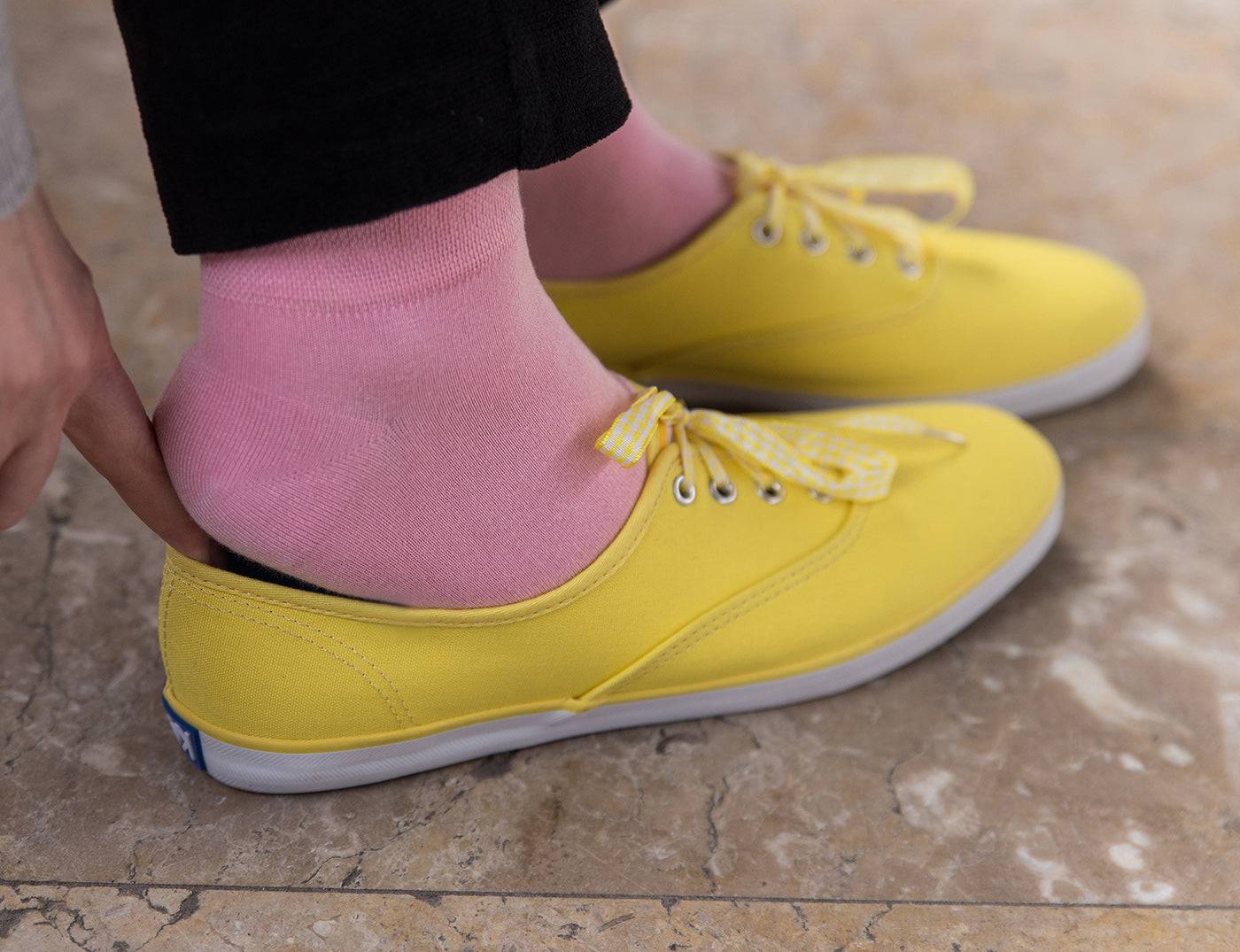 Pink ankle socks worn with yellow lace-up shoes