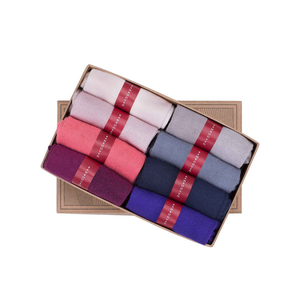 8-pack of low-cut ankle socks folded in box, mixed light pink, gray, plum, and blue.