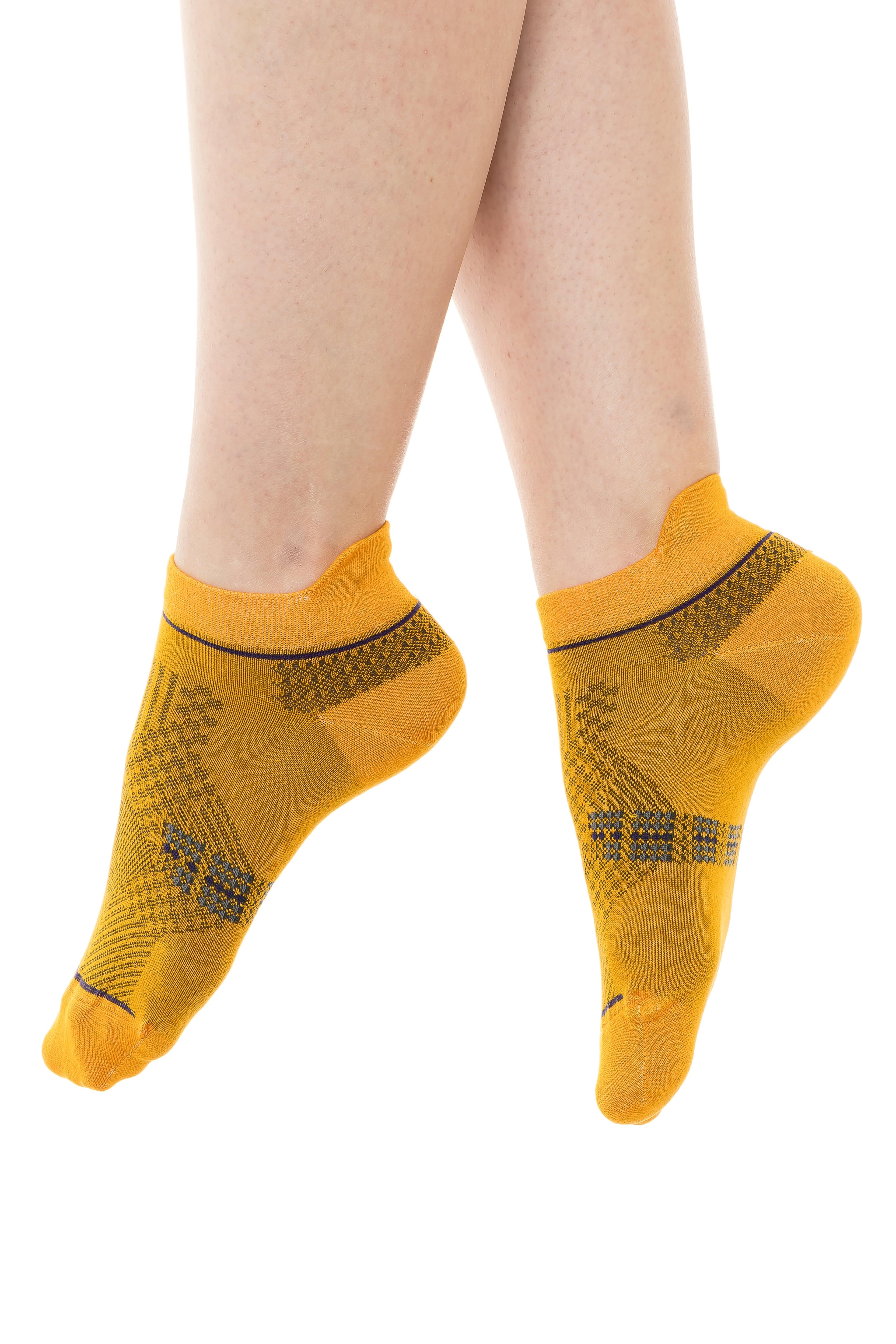 Yellow ankle socks with darker geometric knit pattern at the sides and toe