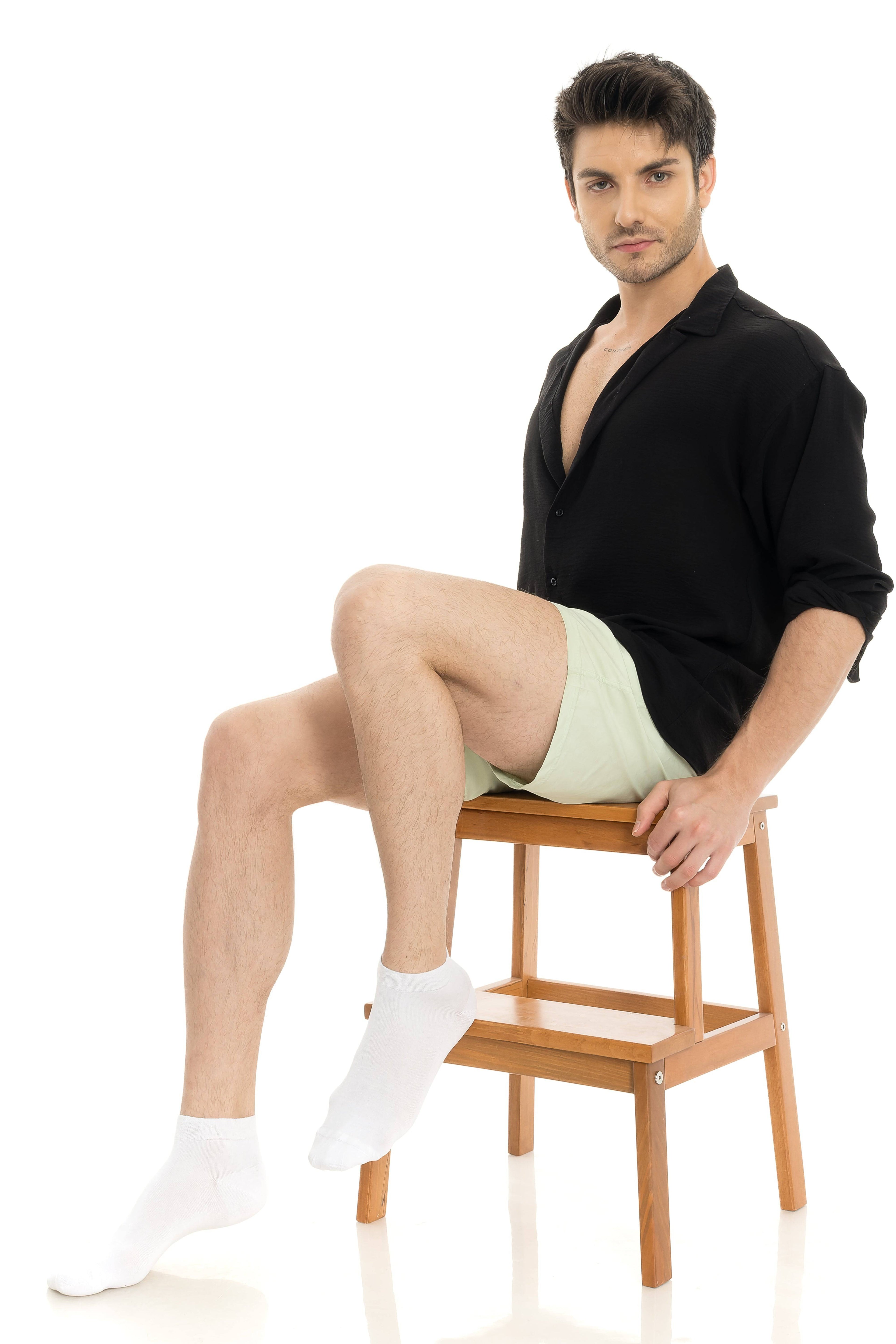 White ankle socks on seated model, visible crew cuffs and smooth knit
