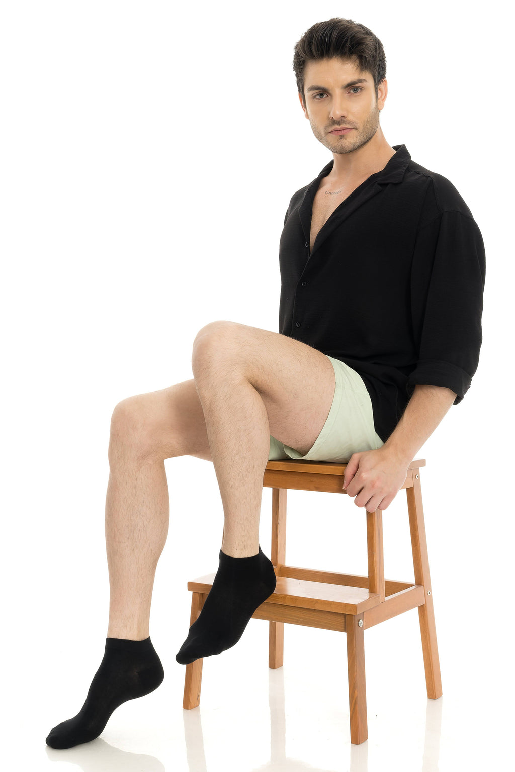 Black ankle socks on seated model, visible cuffs and knit texture