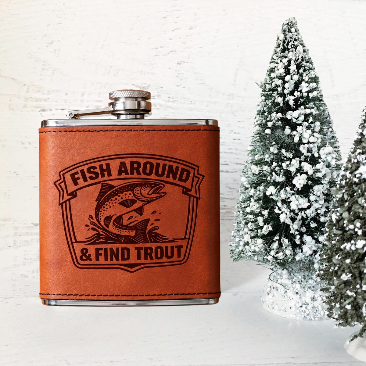 Engraved stainless steel hip flask with tan leather front panel and trout logo
