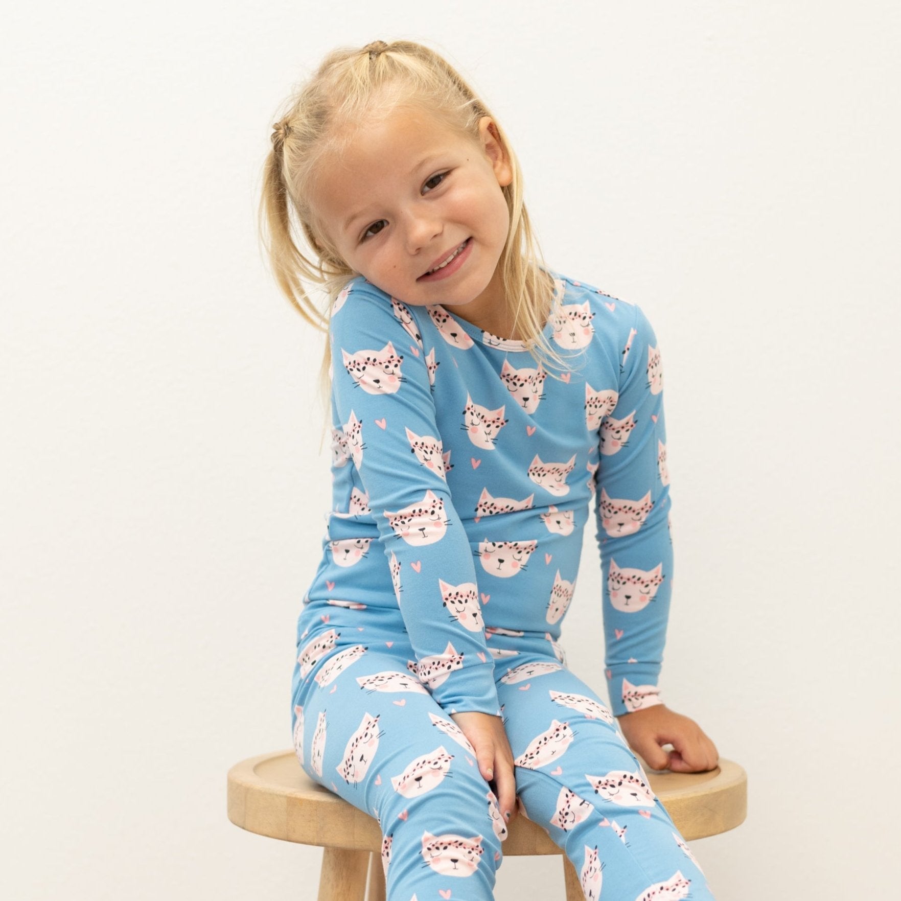 Light blue two-piece kids pajama set with pink cat face print, long sleeves