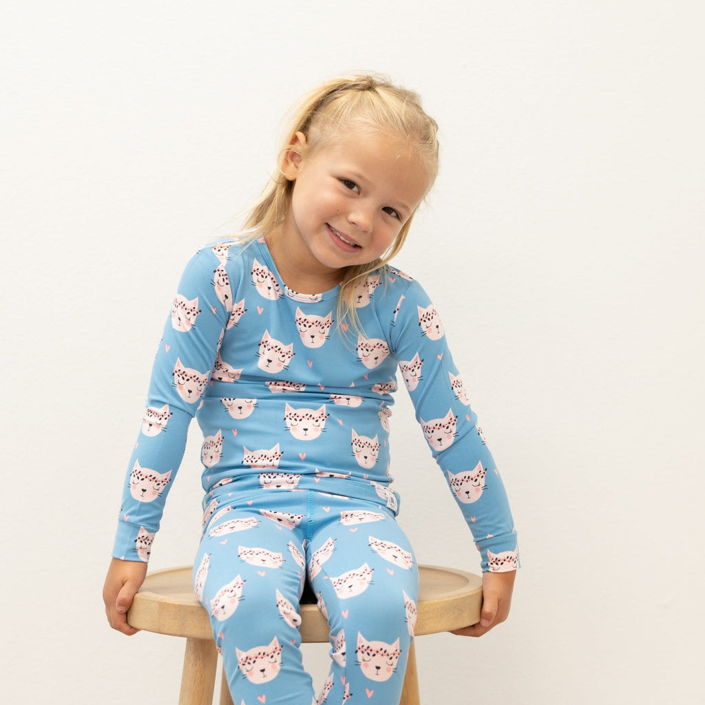 Light blue two-piece kids pajama set with pink cat face print, long sleeves