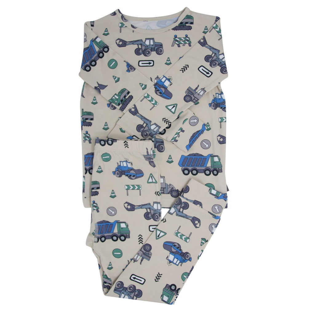Kids construction pajama set with light gray backdrop and blue/green truck graphics