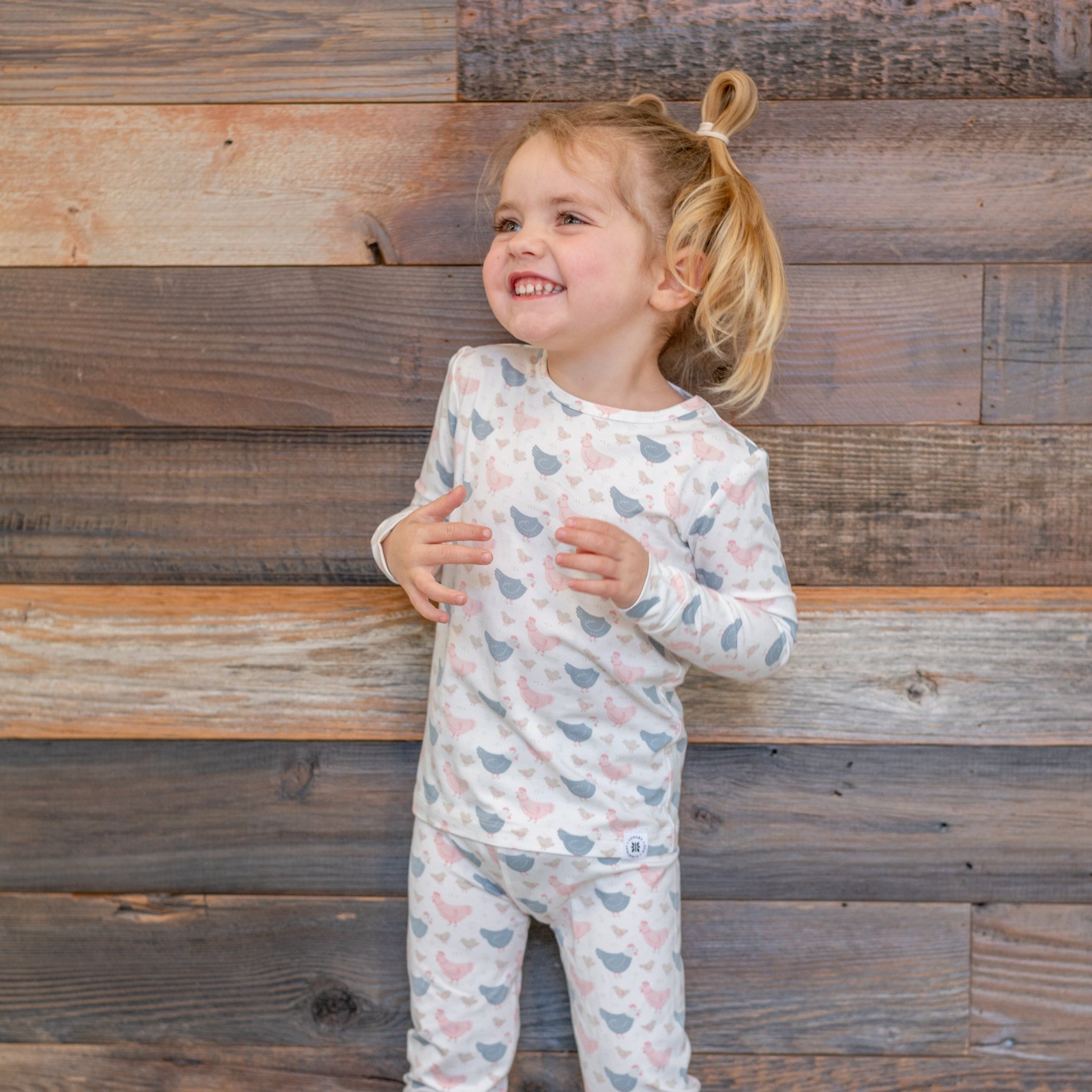 Kids bamboo pajama set with white base and blue/pink farm hen print, long sleeves